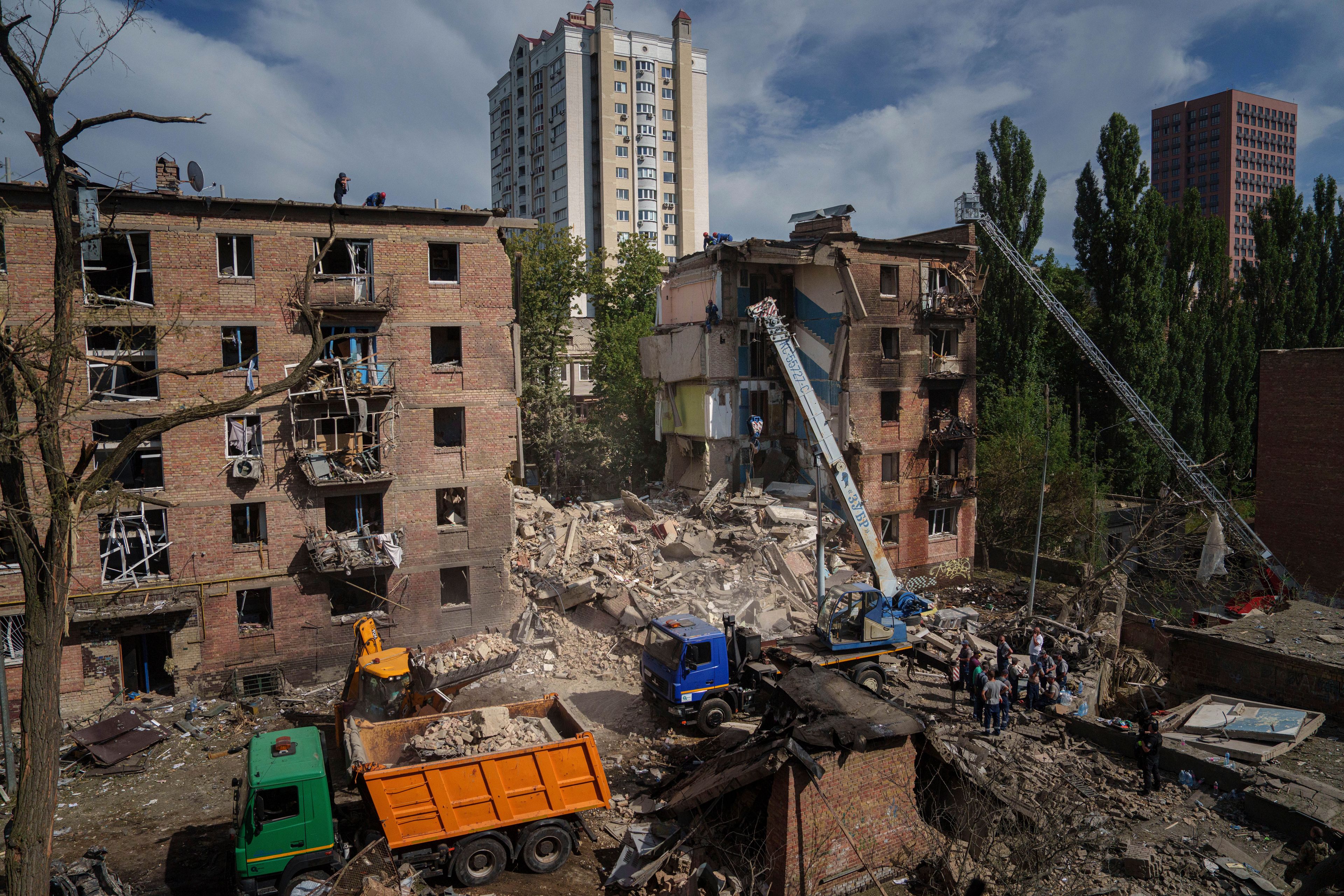 Rescuers clean up the rubble and search victims after Russian missile hit an apartment house in Kyiv, Ukraine, Monday, July 8, 2024. (AP Photo/Evgeniy Maloletka)