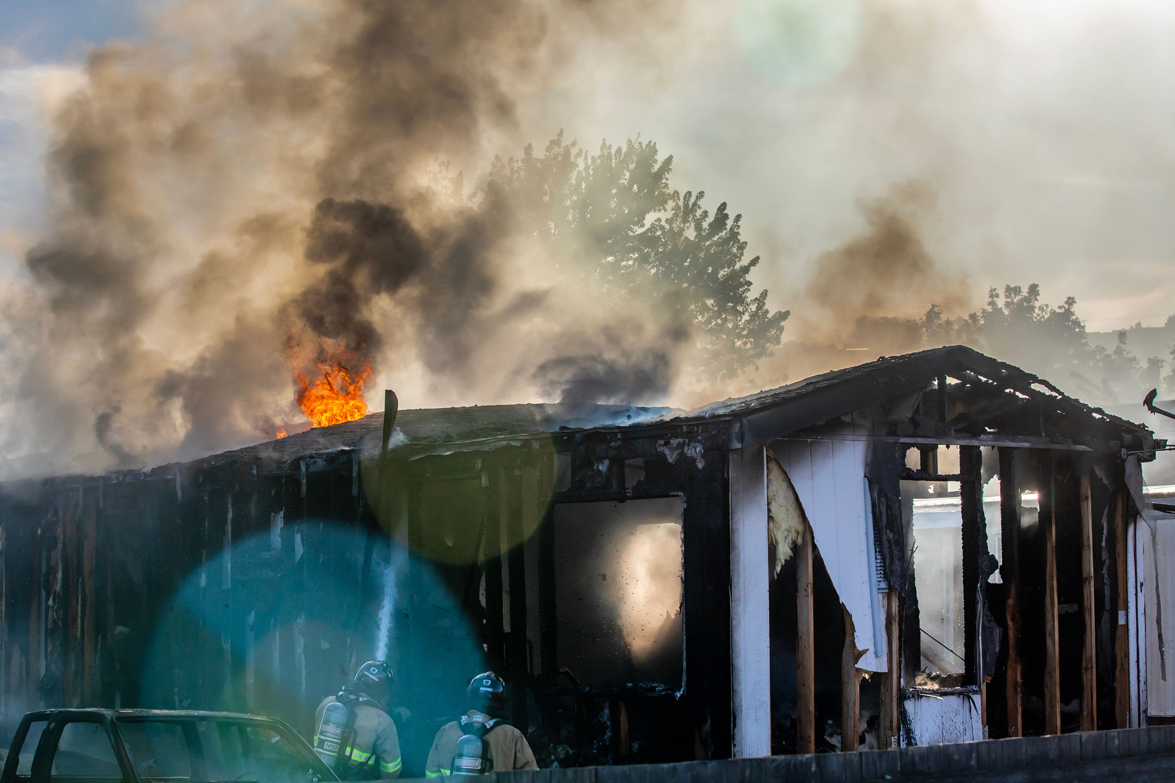 Firefighters spray down some flames on the roof of a mobile home Thursday off 13th Street in Clarkston.