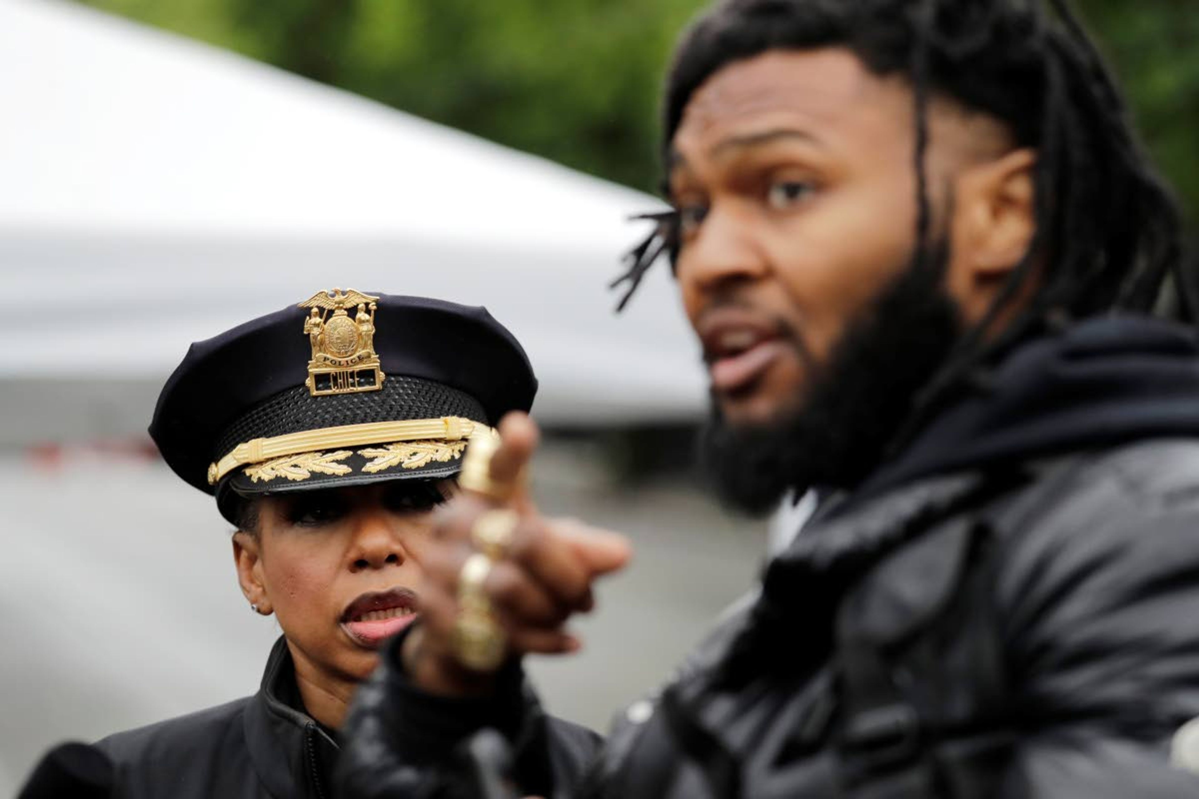 Seattle Police Chief Carmen Best listens to activist Raz Simone as they talk Tuesday near a plywood-covered and closed Seattle police precinct.