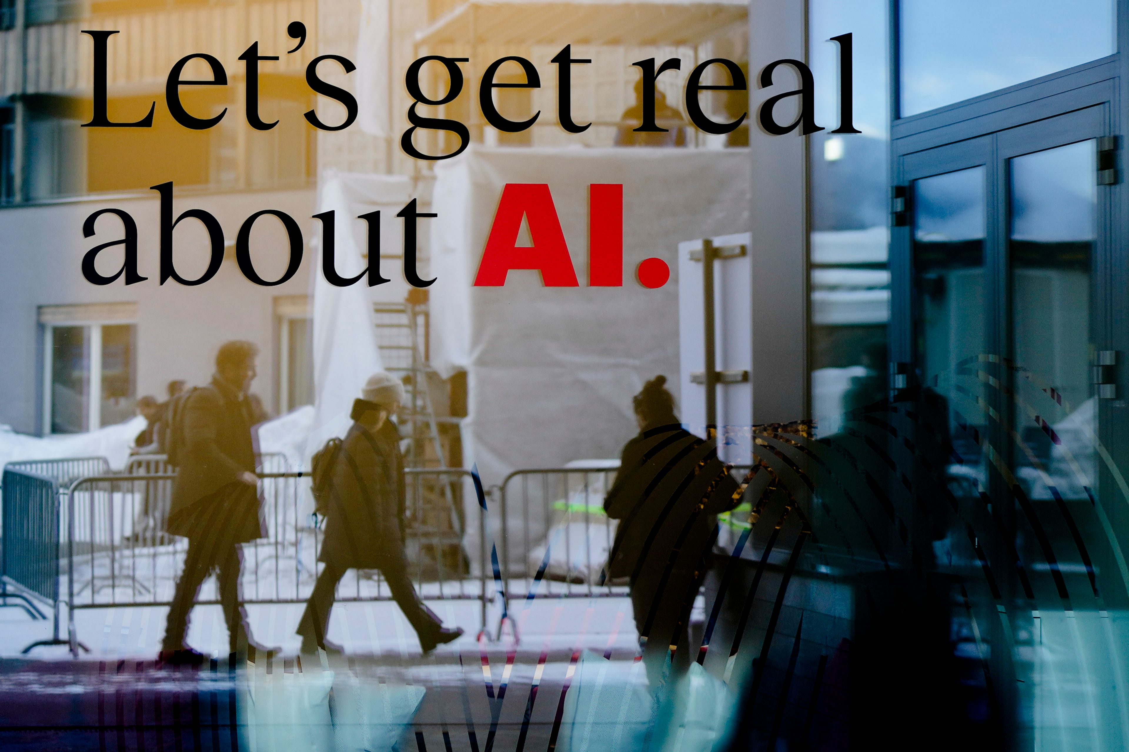 FILE - People are reflected in a window of a hotel at the Davos Promenade in Davos, Switzerland, Jan. 15, 2024. Artificial intelligence is supercharging the threat of election disinformation worldwide, making it easy for anyone to create fake – but convincing – content aimed at fooling voters. (AP Photo/Markus Schreiber, File)