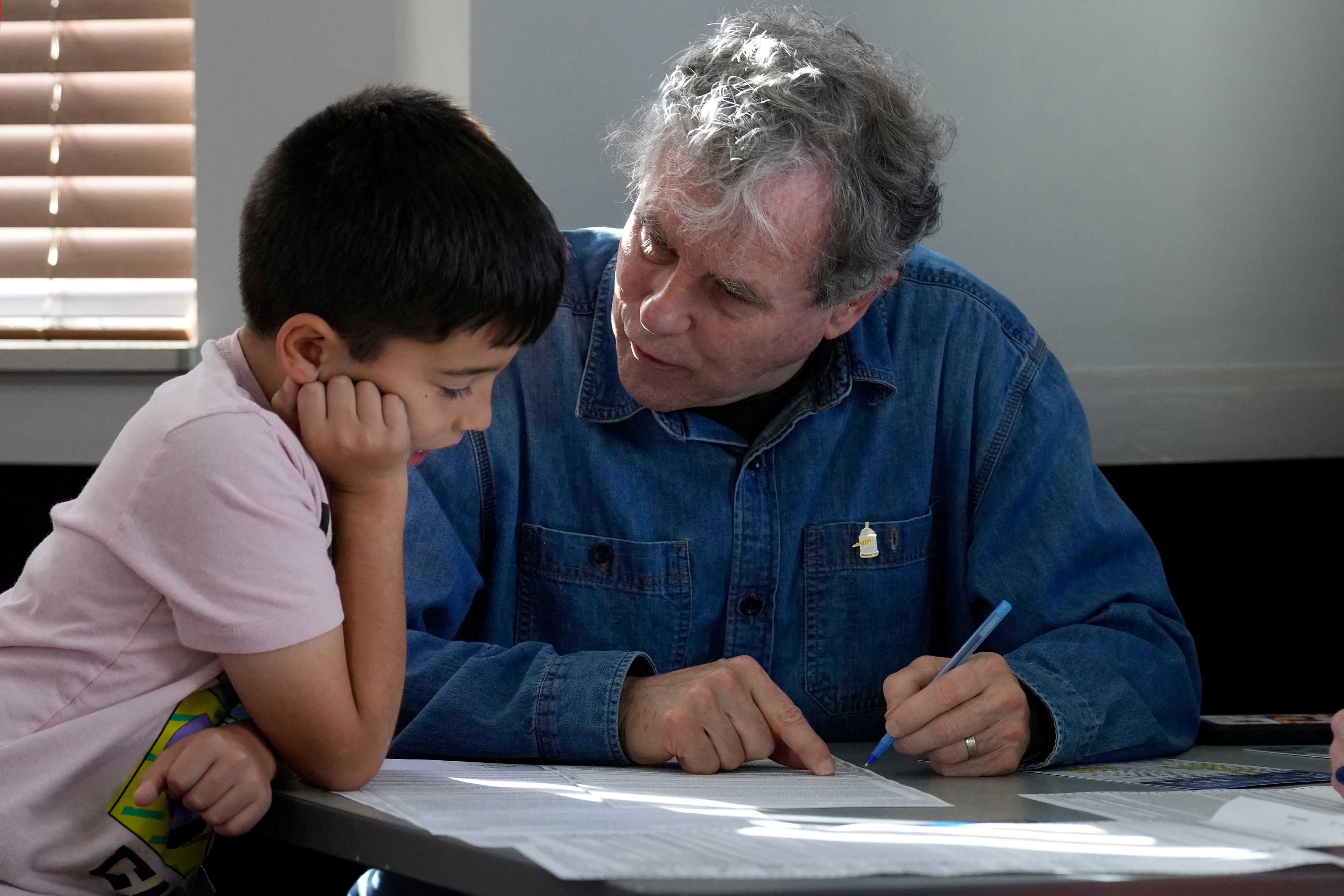 Sen. Sherrod Brown, D-Ohio, fills out his ballot with his grandson, Milo Molina, left, 8, Tuesday, Nov. 5, 2024, in Cleveland. (AP Photo/Sue Ogrocki