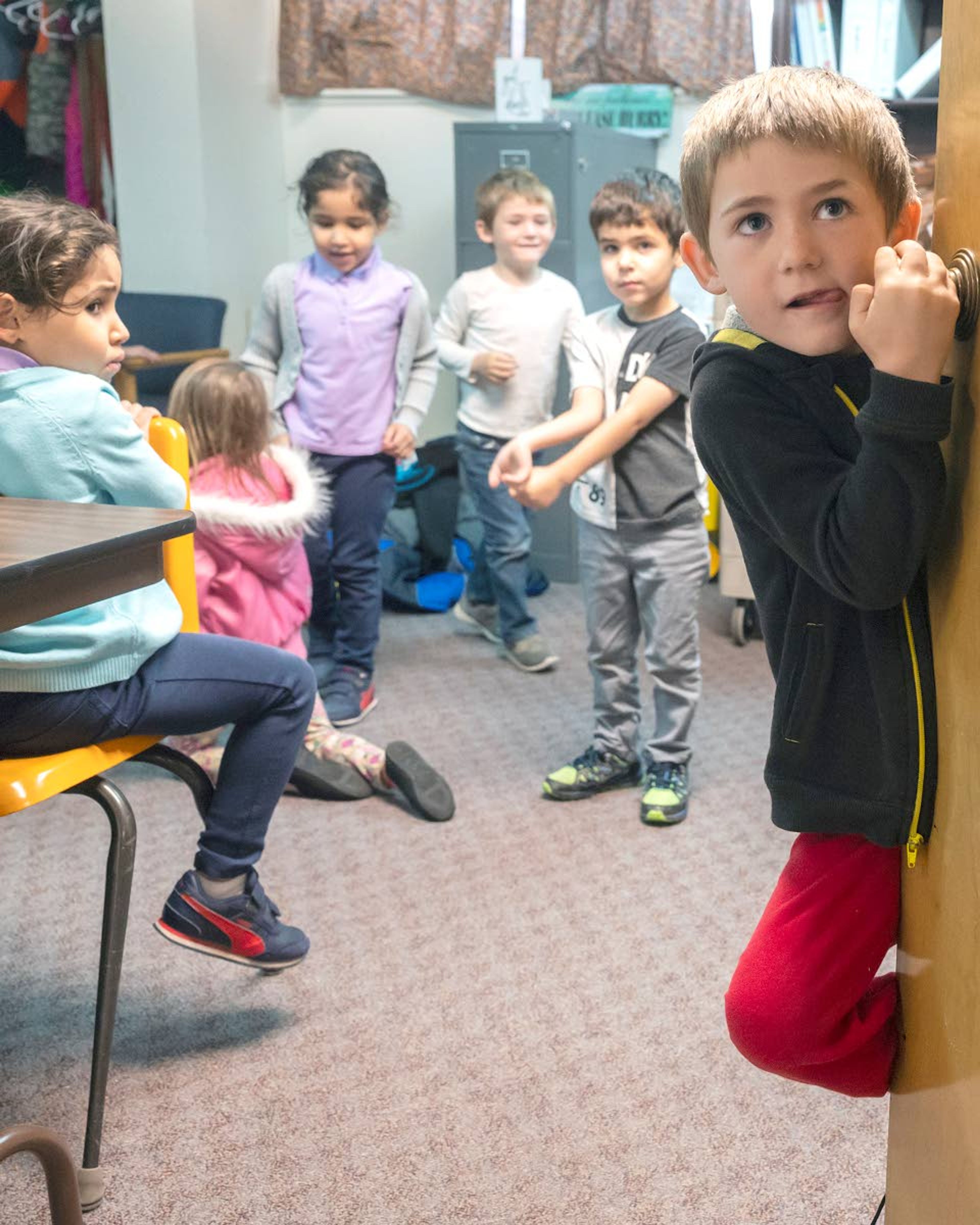 Karson Raney hangs on a doorknob while the other sets of twins mingle in a room at last week at Grantham Elementary in Clarkston.