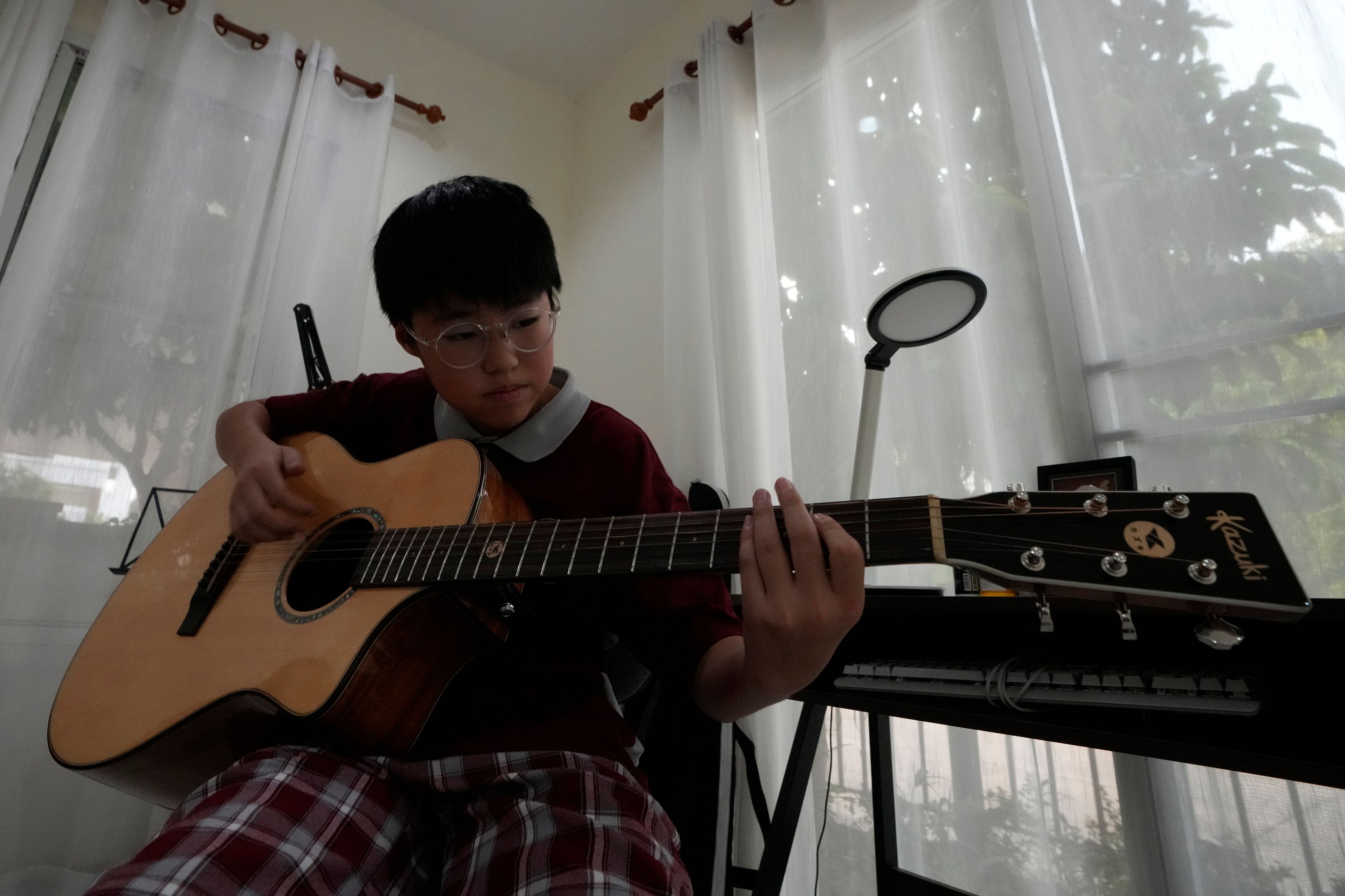 Rodney Feng plays the acoustic guitar in Chiang Mai province, Thailand, Tuesday, April 23, 2024.