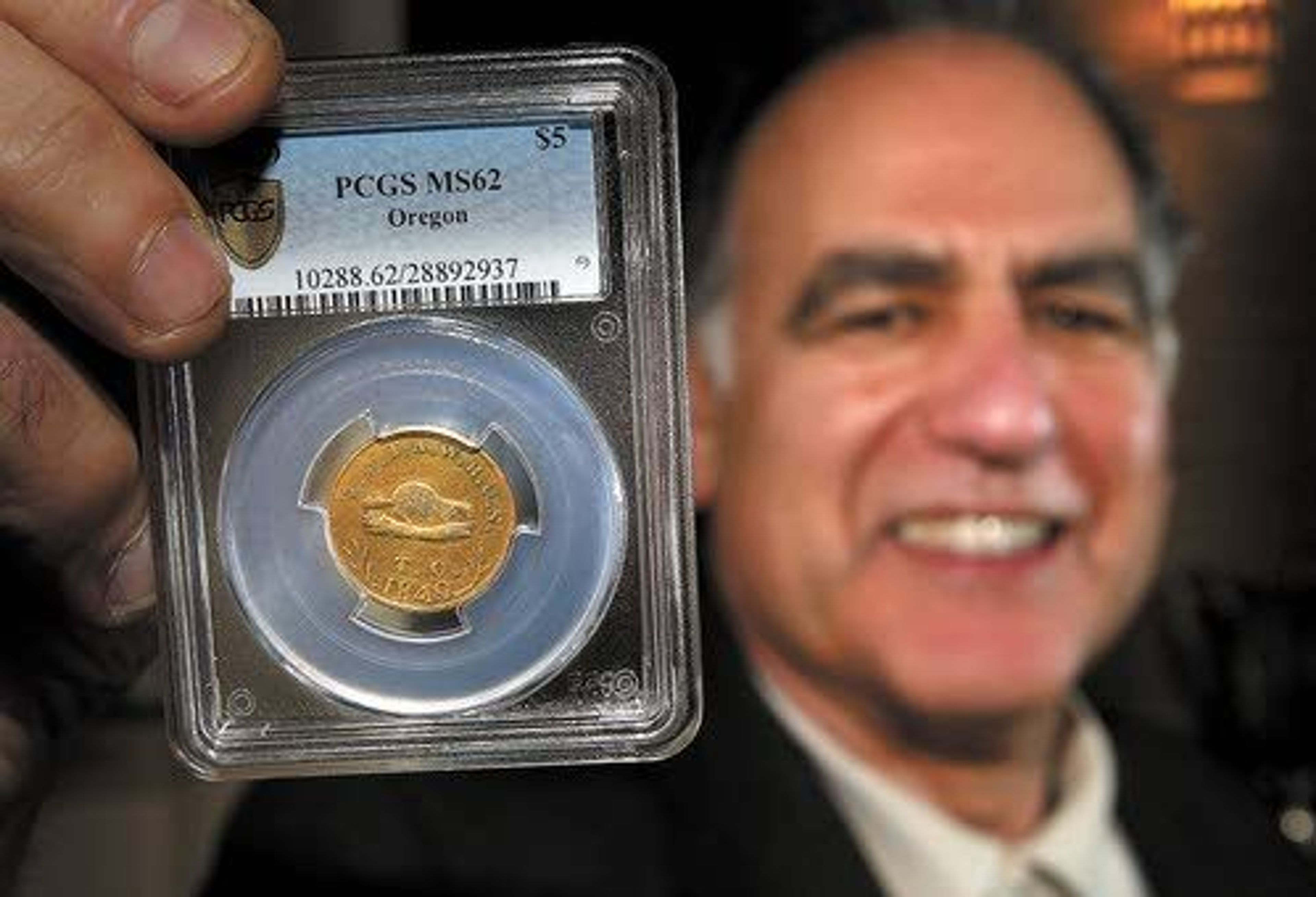 Collector David Nelkin displays a rare gold coin that was made in Oregon City in 1849, at his coin store in Eugene, Ore., Tuesday.