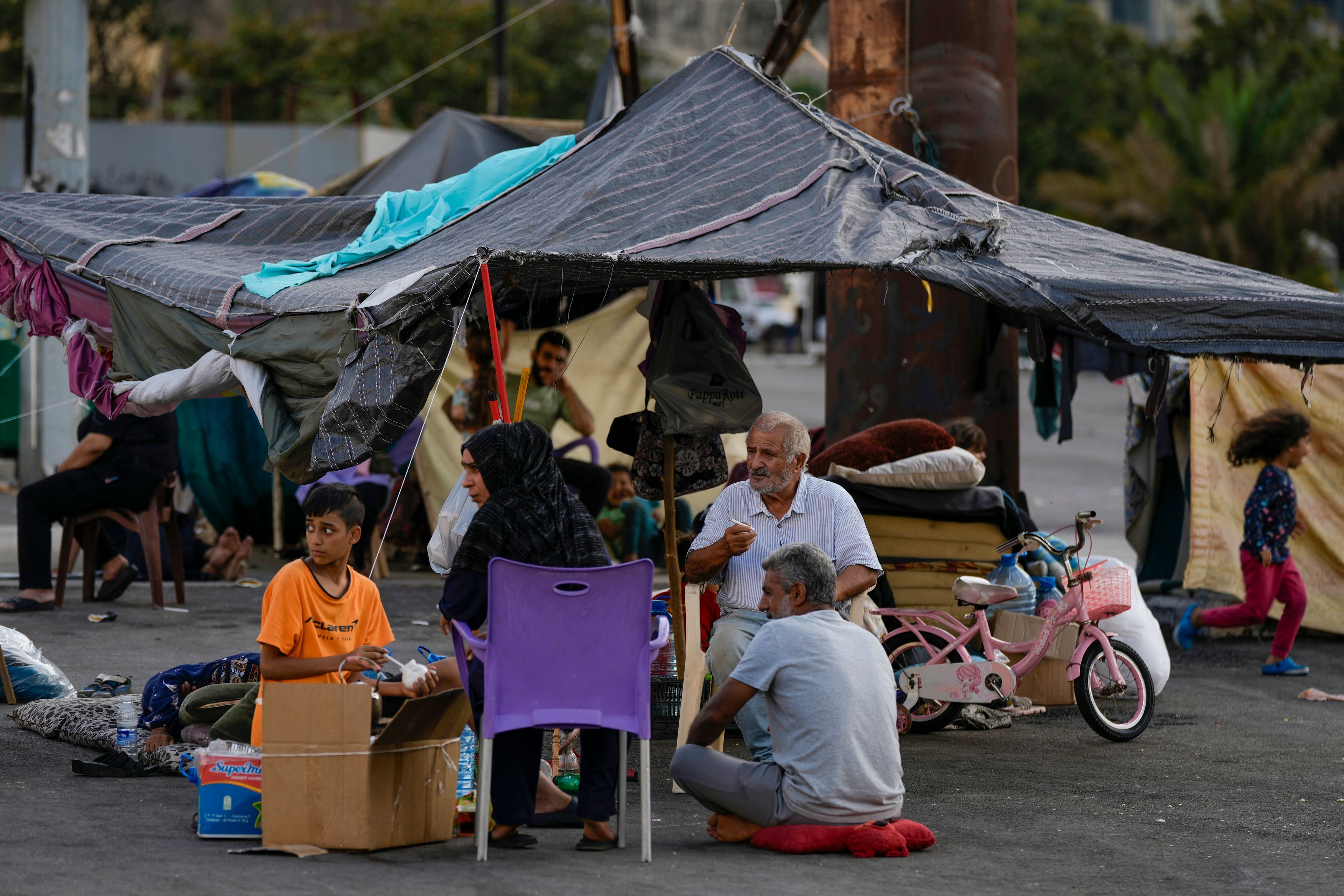 Families fleeing Israeli airstrikes in the south, sit in Martyrs' square, in Beirut, Lebanon, Monday, Oct. 14, 2024. (AP Photo/Bilal Hussein)