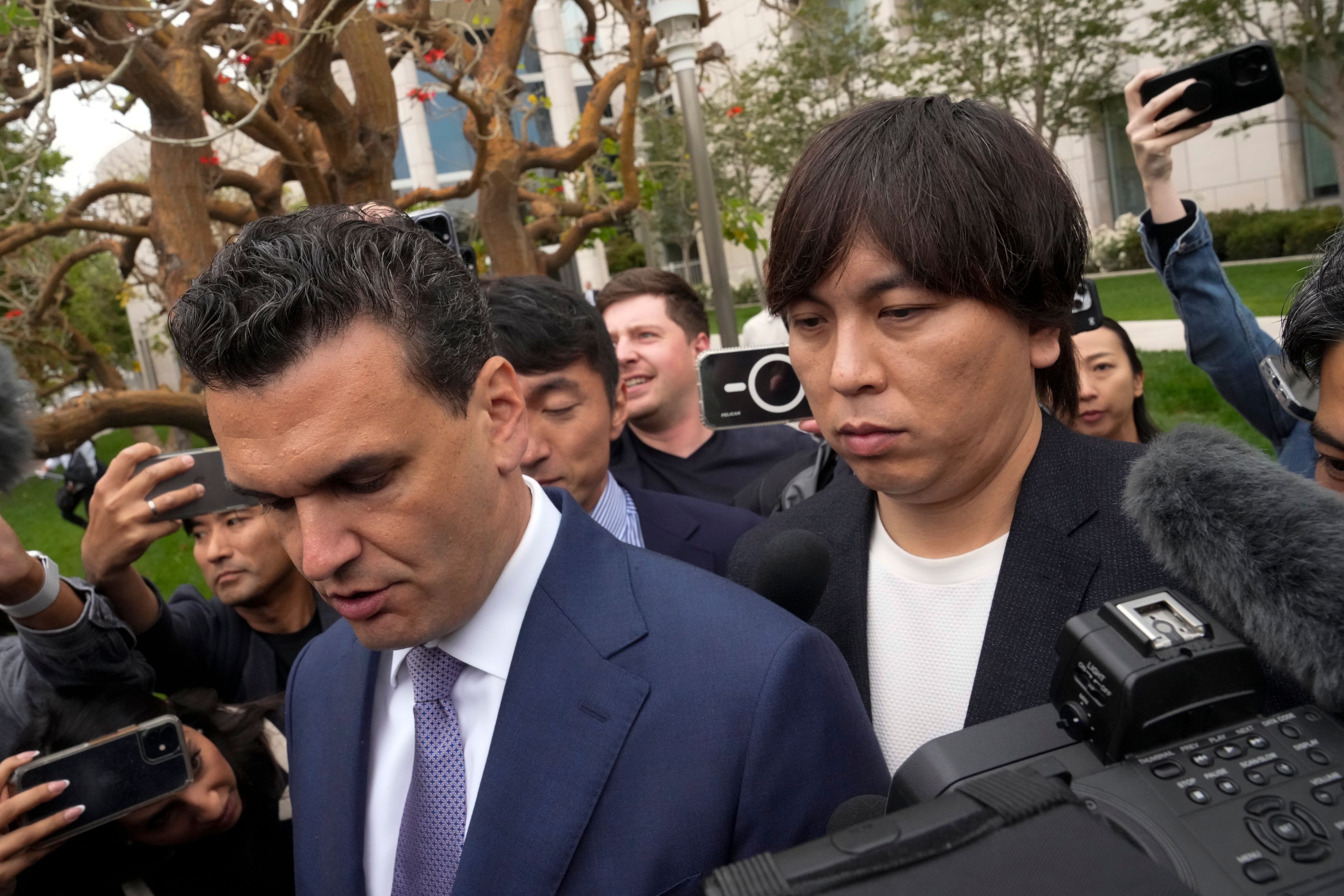 Ippei Mizuhara, right, the former interpreter for the Los Angeles Dodgers baseball star Shohei Ohtani, and his defense attorney, Michael Freedman, leave federal court in Los Angeles, Tuesday, June 4, 2024, after Mizuhara pleaded guilty to bank and tax fraud in a sports betting case.