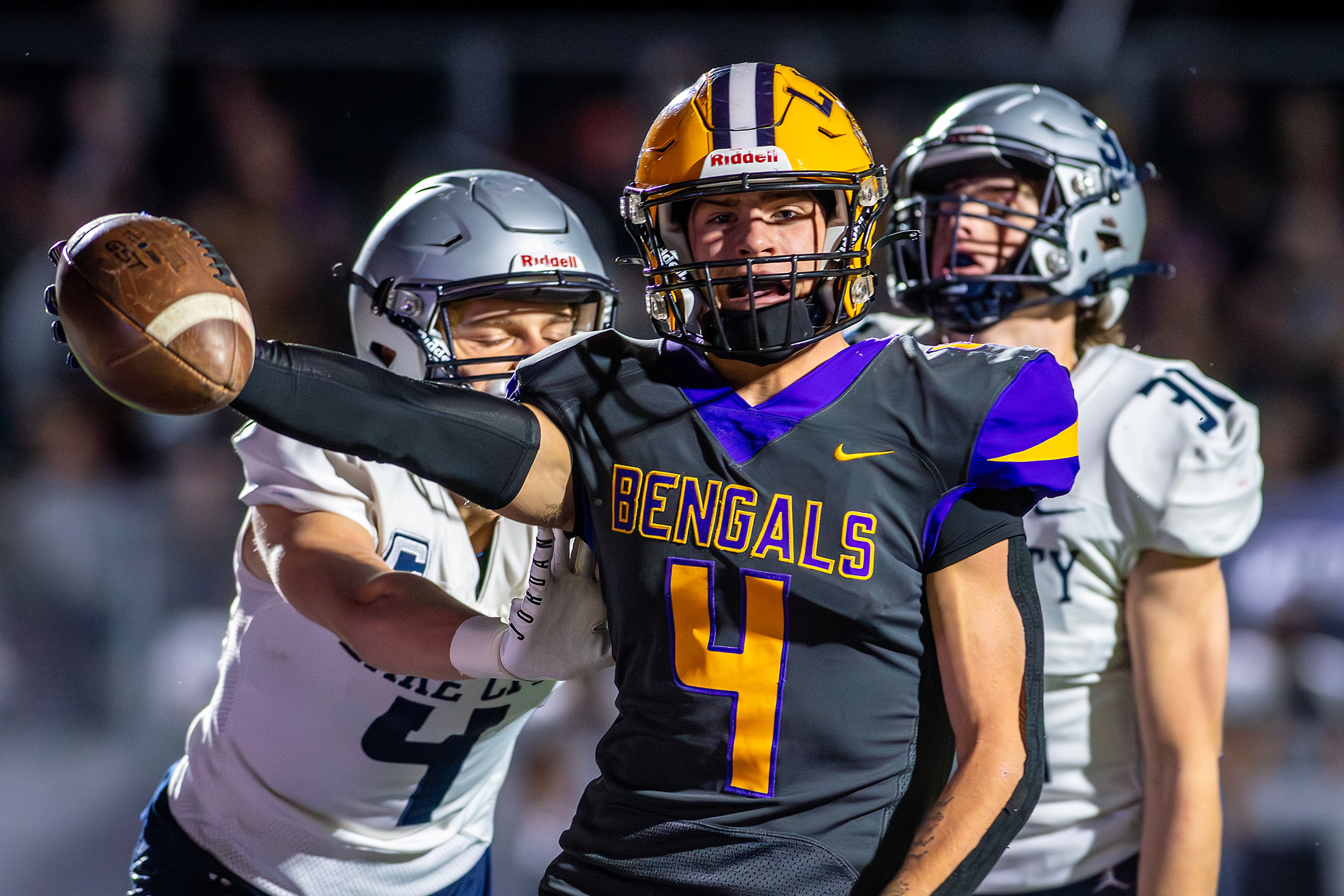 Lewiston running back Noah Carpenter holds the ball out while Lake City reacts as he scores a touchdown in a nonconference game Friday at P1FCU Sports Complex.