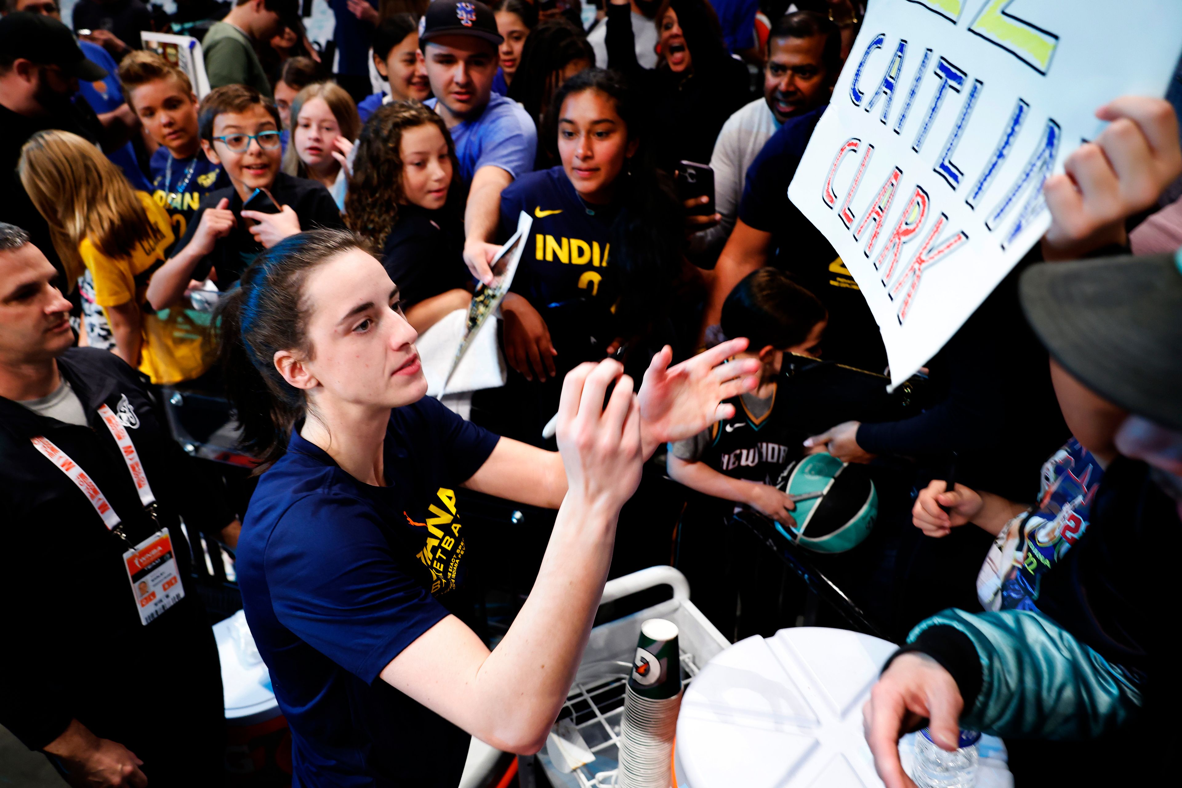 FILE - Indiana Fever guard Caitlin Clark signs autographs for fans before the start of WNBA basketball game against the New York Liberty, Saturday, May 18, 2024, in New York.