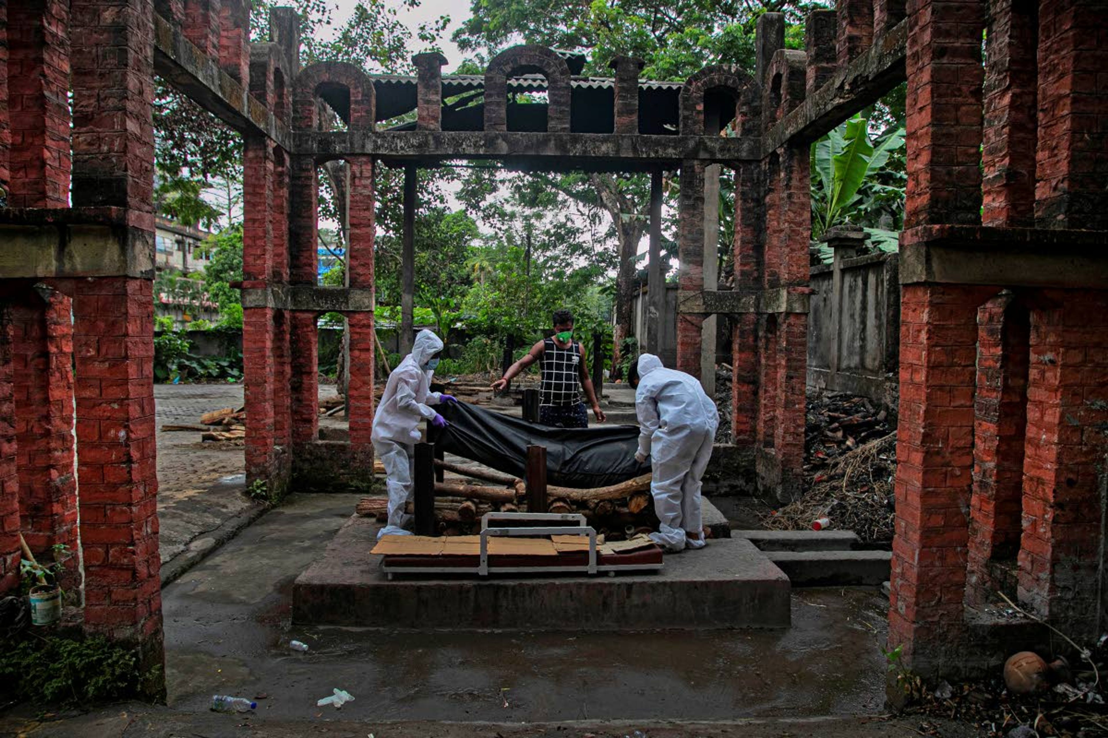 Ramananda Sarkar, 43, gives instruction to health workers before cremating the body of a COVID-19 victim in Gauhati, India, Tuesday, Sept. 15, 2020. People who deal with corpses face stigma that's only been made worse by the coronavirus, which has killed more than 100,000 people in India out of 6.4 million reported infections. When his landlord heard about Sarkar's work, he told him he would have to move out. Thankfully a district official arranged a hotel room for him. Sarkar was also stopped from returning to his village to visit his family, first by the village head and then, after local authorities intervened on his behalf, by the villagers themselves. (AP Photo/Anupam Nath)