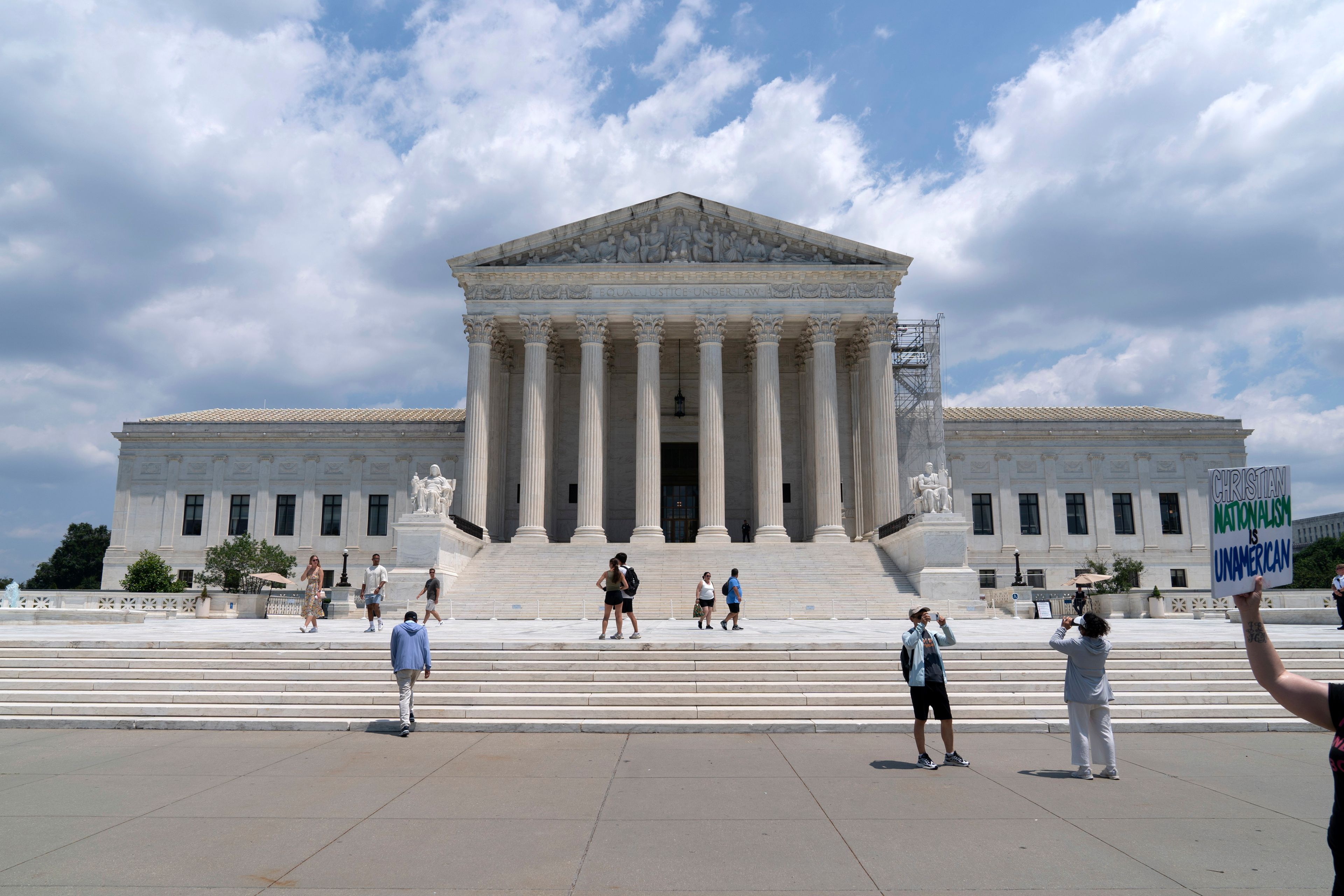 Visitors pose for photographs outside the U.S. Supreme Court Tuesday, June 18, 2024, in Washington. ( AP Photo/Jose Luis Magana)