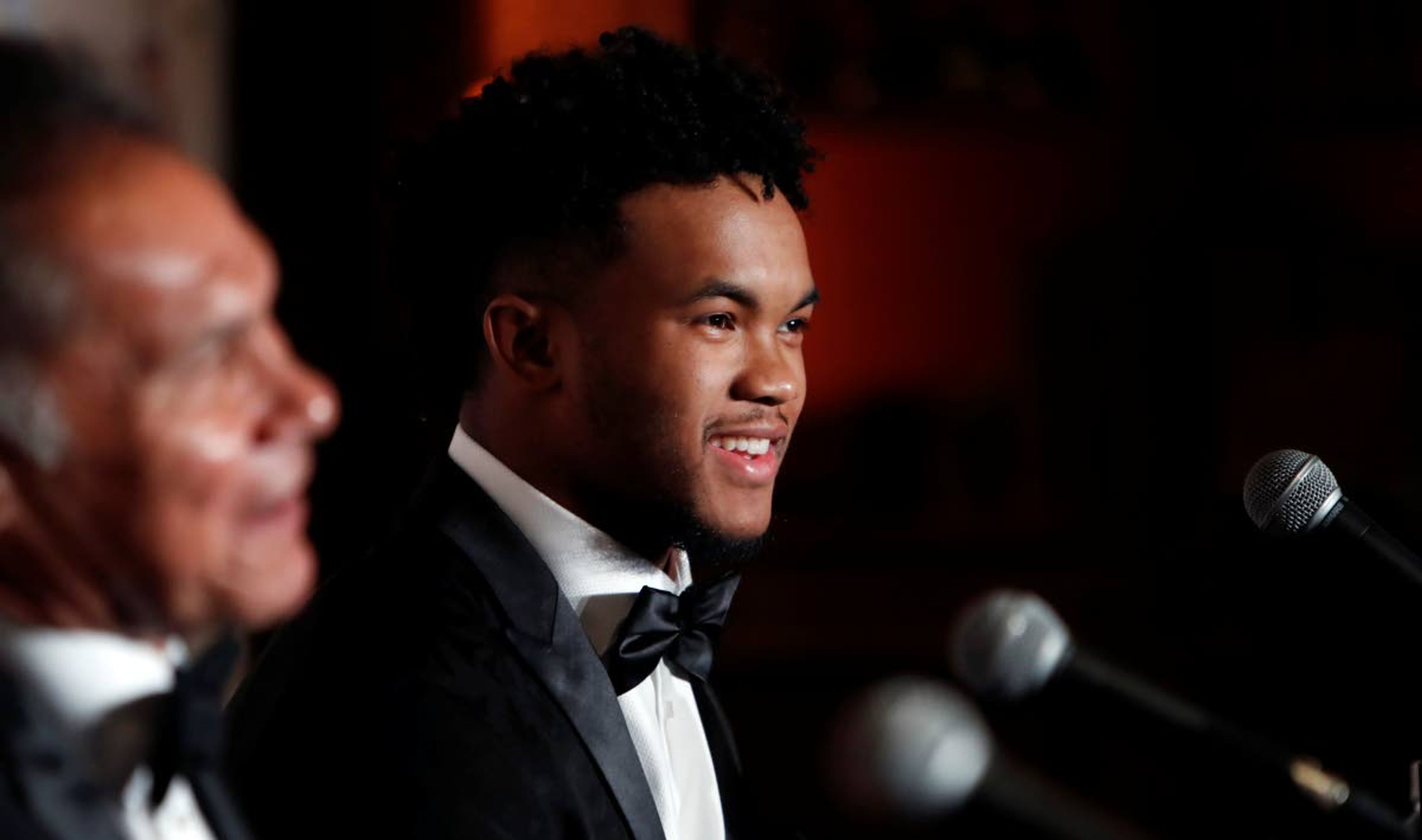 Heisman Trophy winner quarterback Kyler Murray, right, smiles during the Davey O'Brien Award news conference in Fort Worth, Texas, Monday, Feb. 18, 2019. Murray accepted the award in his first public appearance since he announced his plan to pursue an NFL football career rather than report to spring training as a first-round pick of the Oakland A's. (AP Photo/LM Otero)