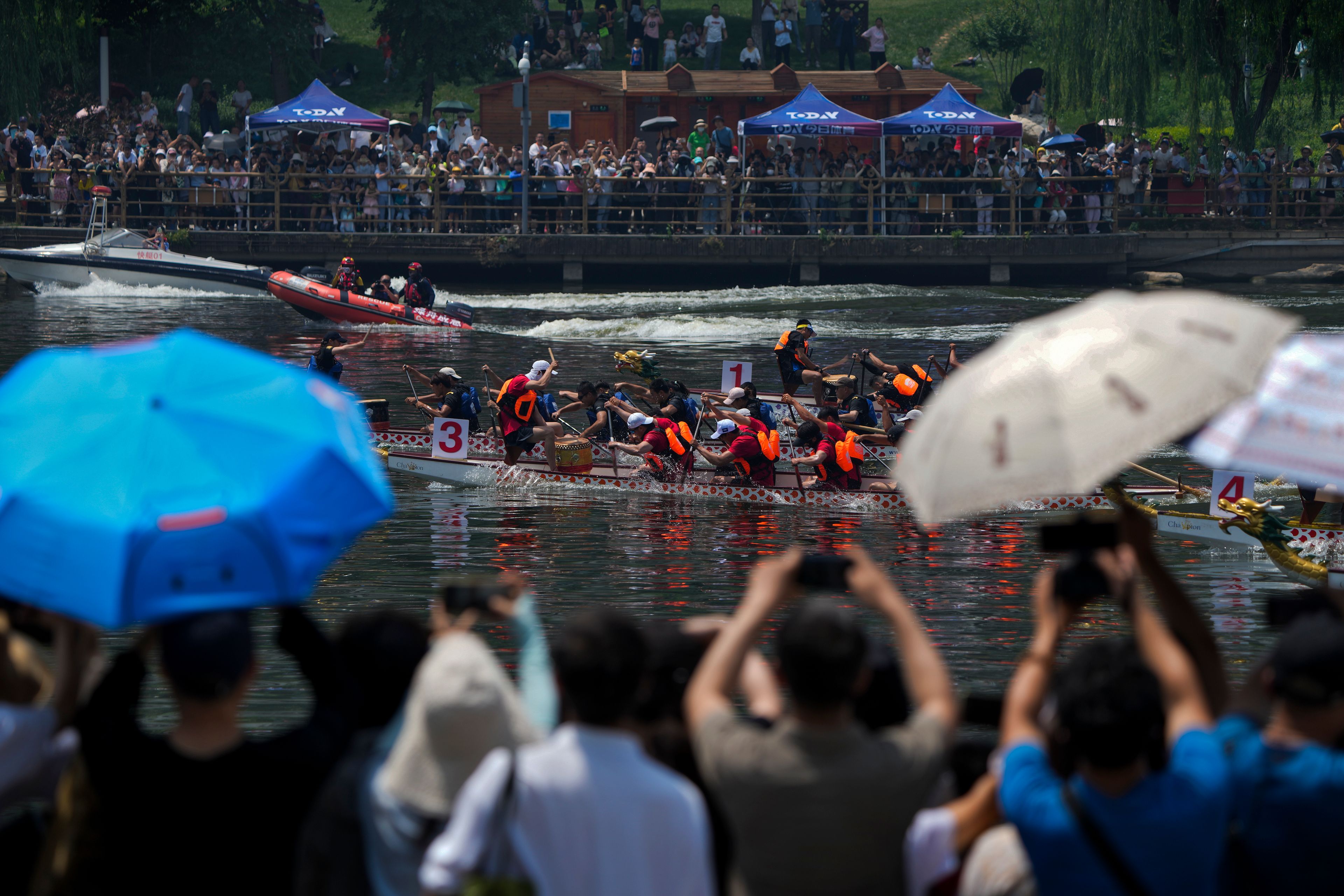 Residents watch a dragon boat race during the Dragon Boat Festival at a canal in Tongzhou, outskirts of Beijing, Monday, June 10, 2024. The Duanwu Festival, also known as the Dragon Boat Festival, falls on the fifth day of the fifth month of the Chinese lunar calendar and is marked by eating rice dumplings and racing dragon boats.