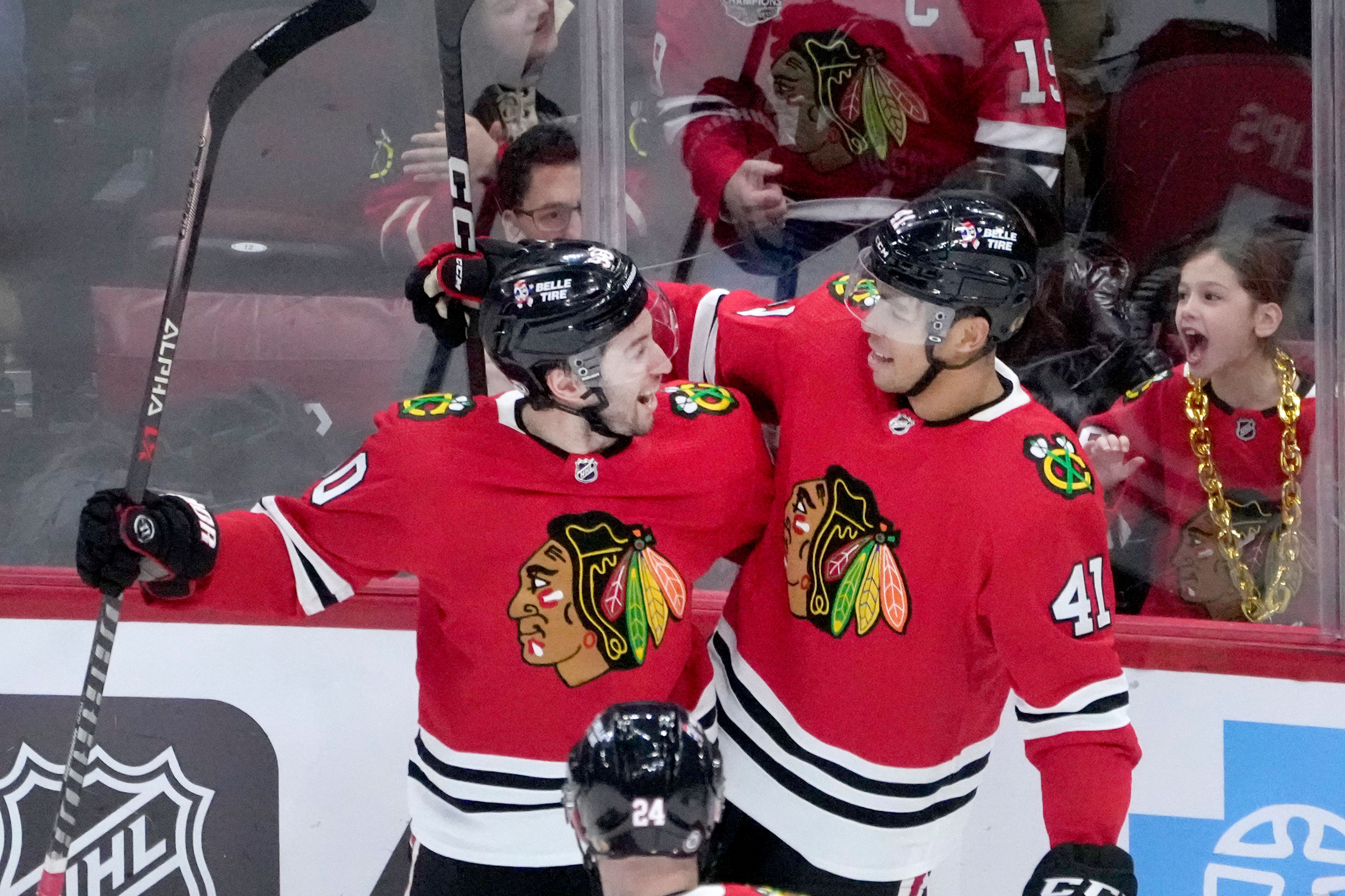 Chicago Blackhawks' Isaak Phillips (41) celebrates his first career NHL goal with Tyler Johnson during the second period of a hockey game against the Seattle Kraken, Saturday, Jan. 14, 2023, in Chicago. (AP Photo/Charles Rex Arbogast)