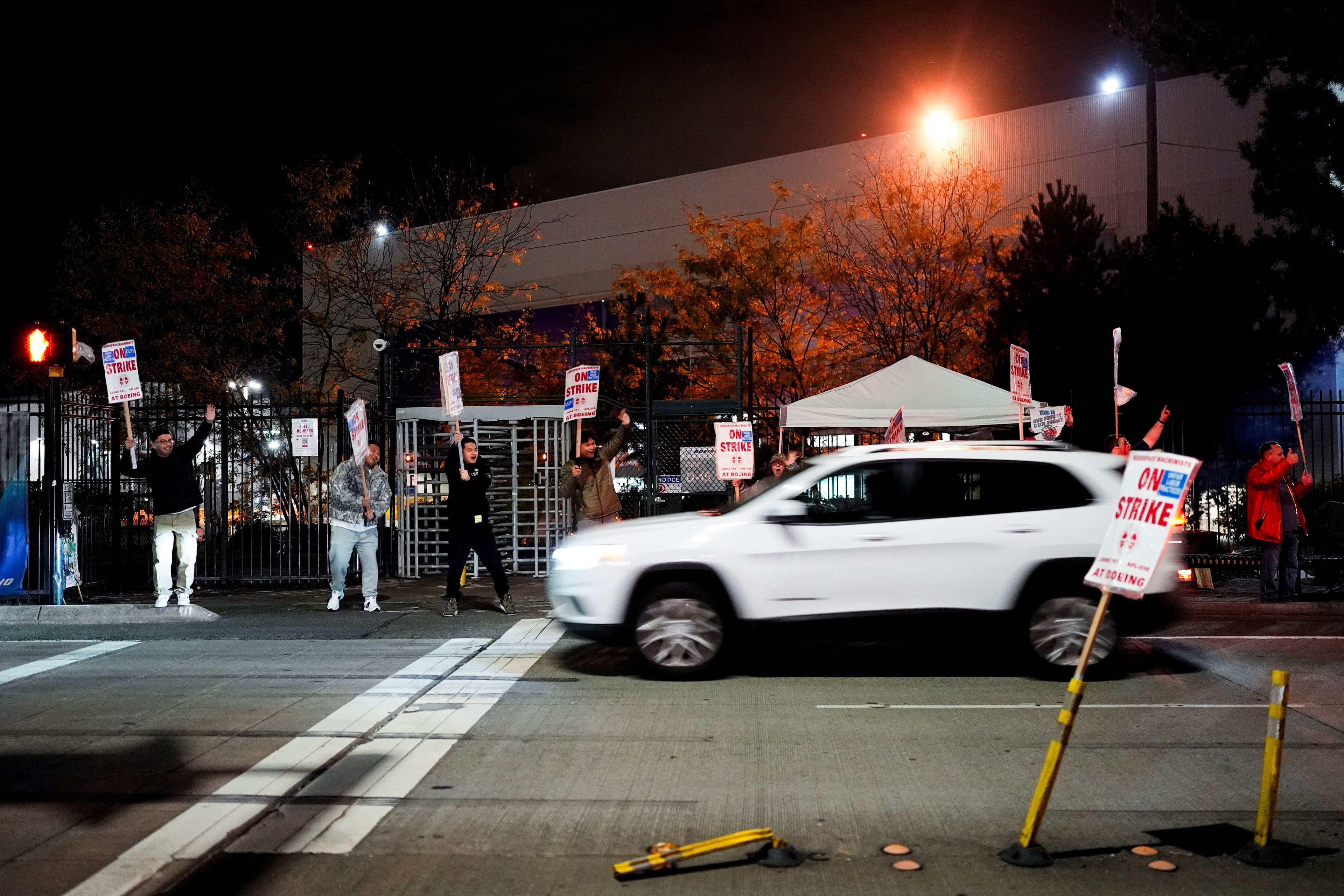 Boeing employees cheer and wave picket signs as a driver honks in support after a majority of union members voted to reject a new contract offer from the company, Wednesday, Oct. 23, 2024, in Renton, Wash. (AP Photo/Lindsey Wasson)