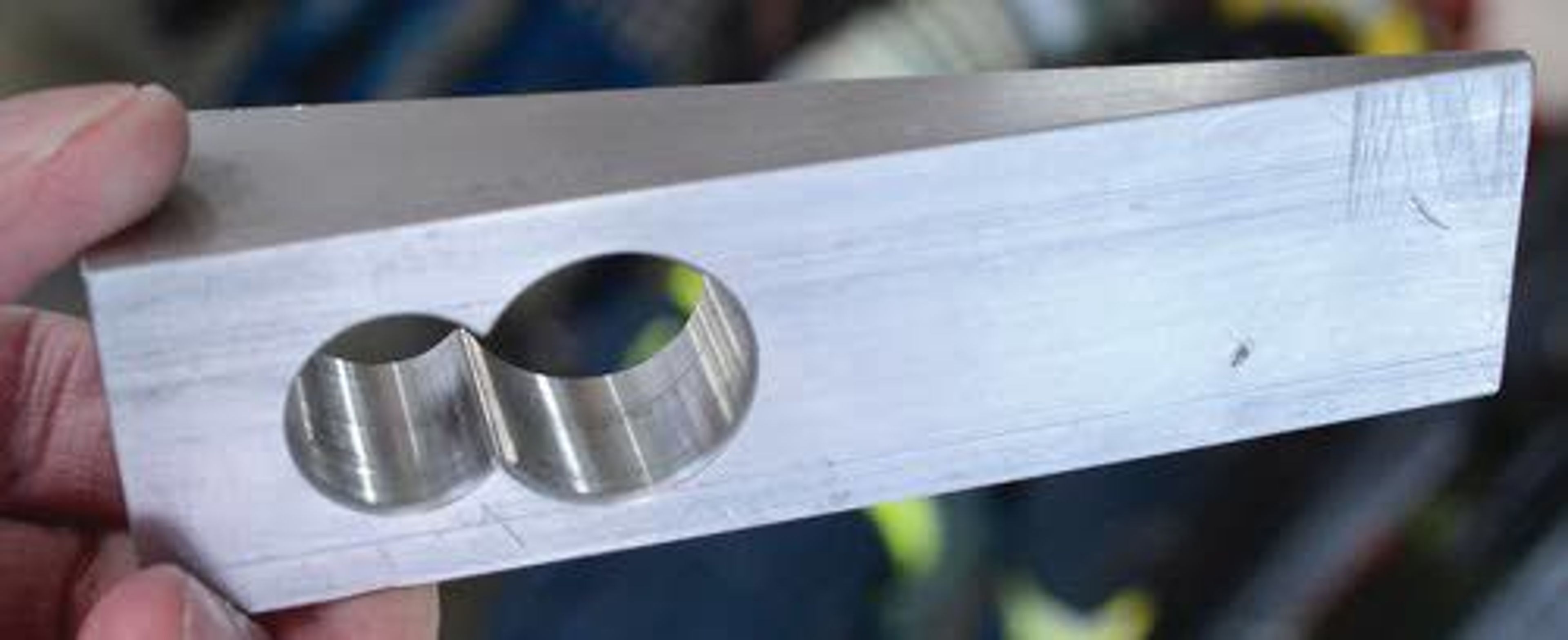 A milled aluminum wedge helps firefighters open locked doors.