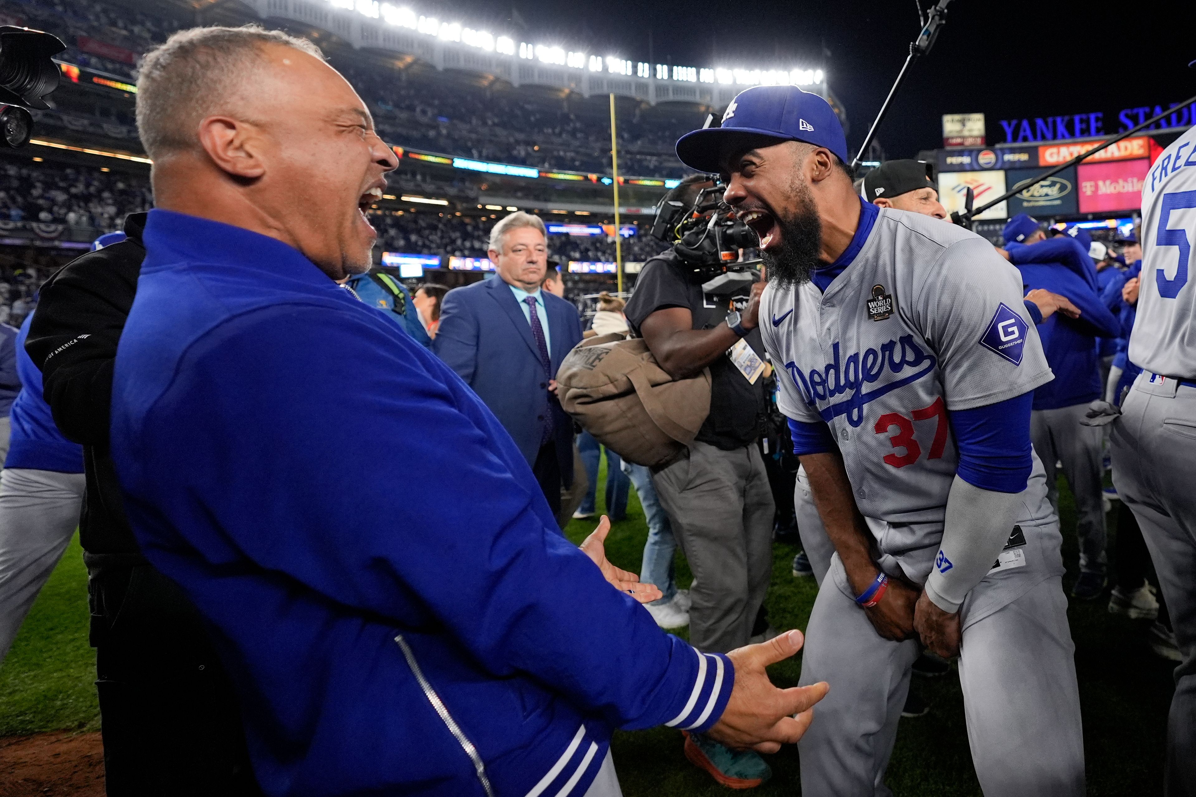 Los Angeles Dodgers manager Dave Roberts and Teoscar HernÃ¡ndez celebrate their win against the New York Yankees in Game 5 to win the baseball World Series, Wednesday, Oct. 30, 2024, in New York. (AP Photo/Ashley Landis)