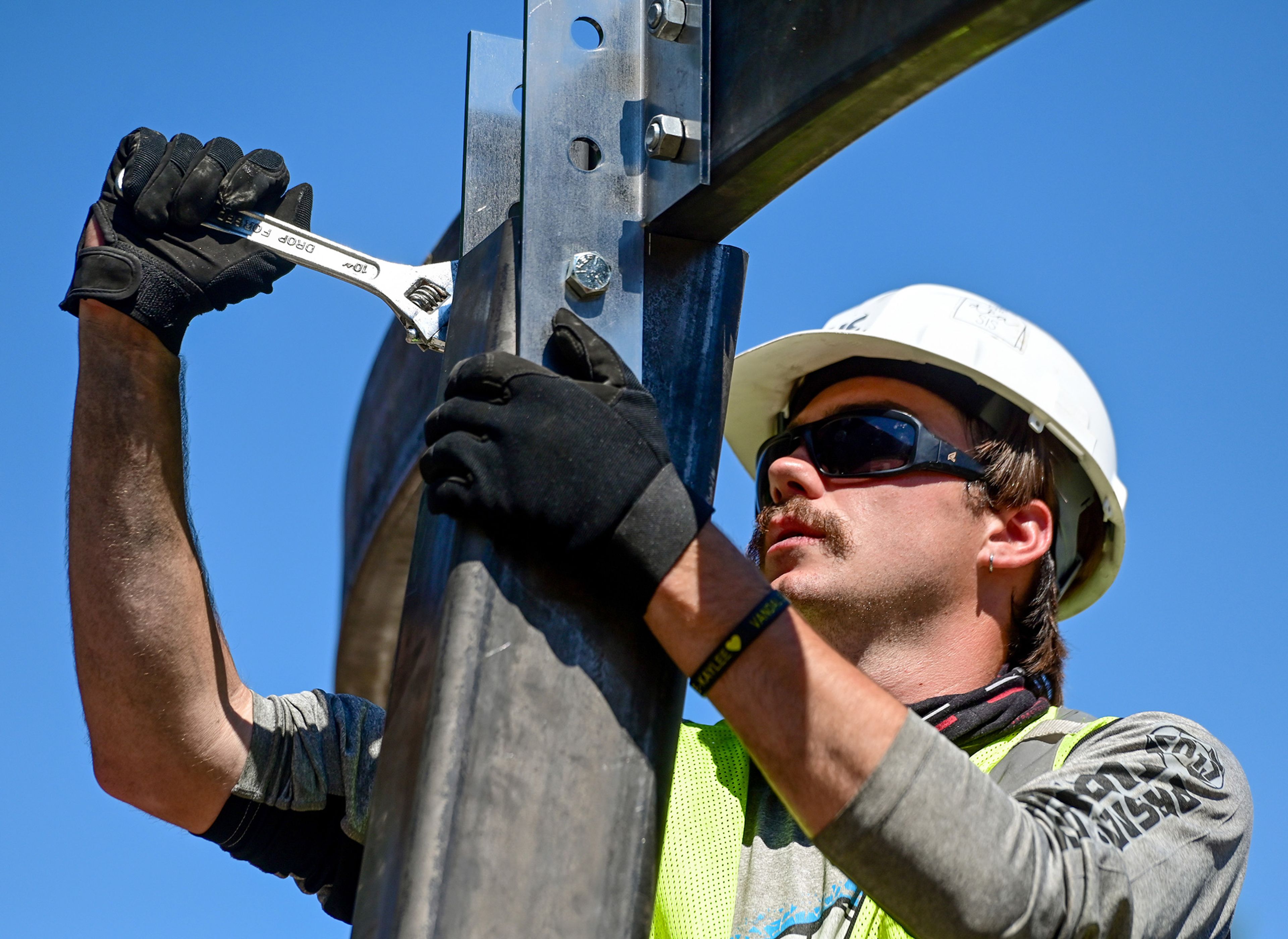 Korbyn Averett, a University of Idaho graduate architecture student, tightens bolts on the memorial structure of the Vandal Healing Garden and Memorial in Moscow on Tuesday.