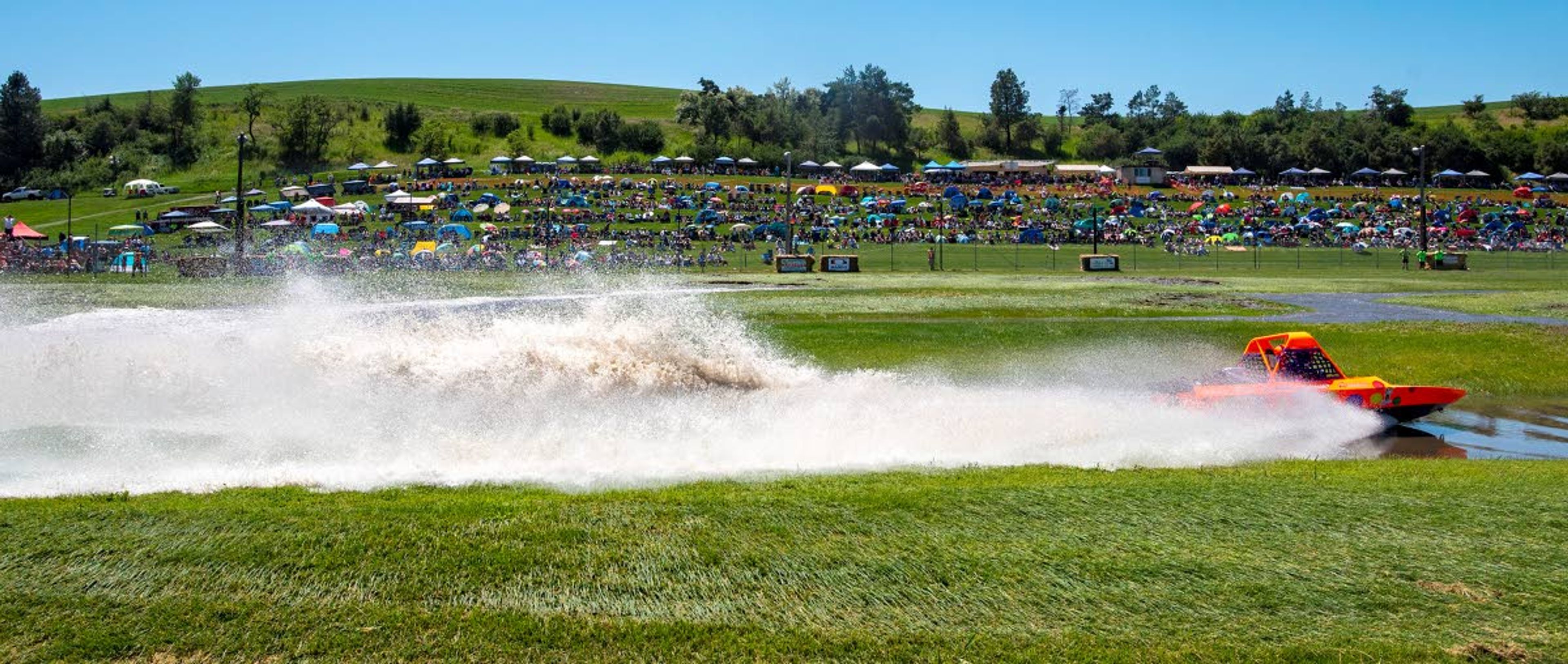 Thousands of lawn-chair clad fans look on as the Ballz Out boat driven by Dean Lautenschlager and navigated by Jack Bringman, both from the Lewiston-Clarkston Valley, zooms along the waterways of Webb's Slough during the qualifying heats in the Unlimited Class on Saturday in St. John.