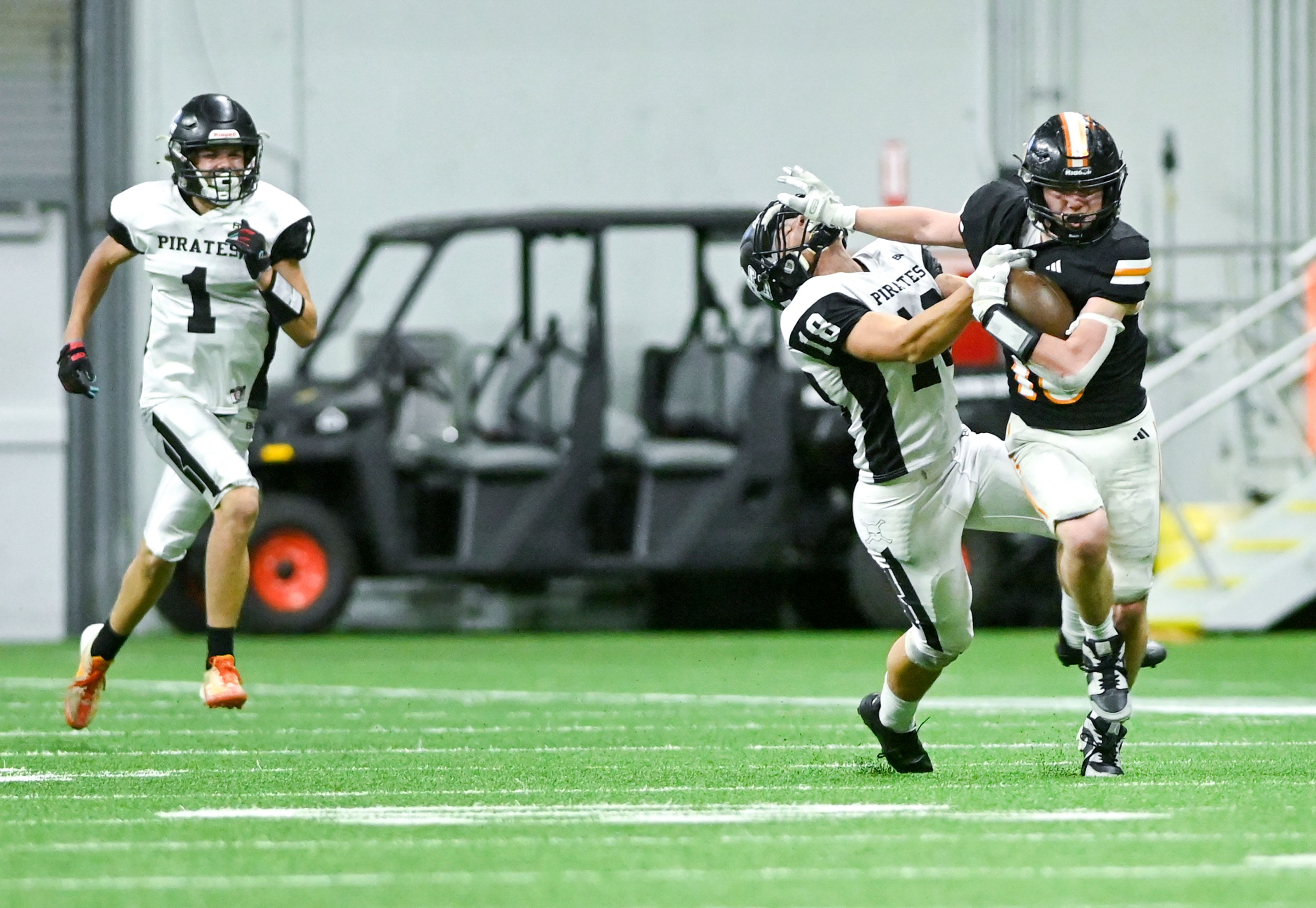 Kendrick’s Xavier Carpenter pushes against Butte County’s Levi Hendriks while carrying the ball Friday during the Idaho 2A football state championship game at the P1FCU Kibbie Dome in Moscow.