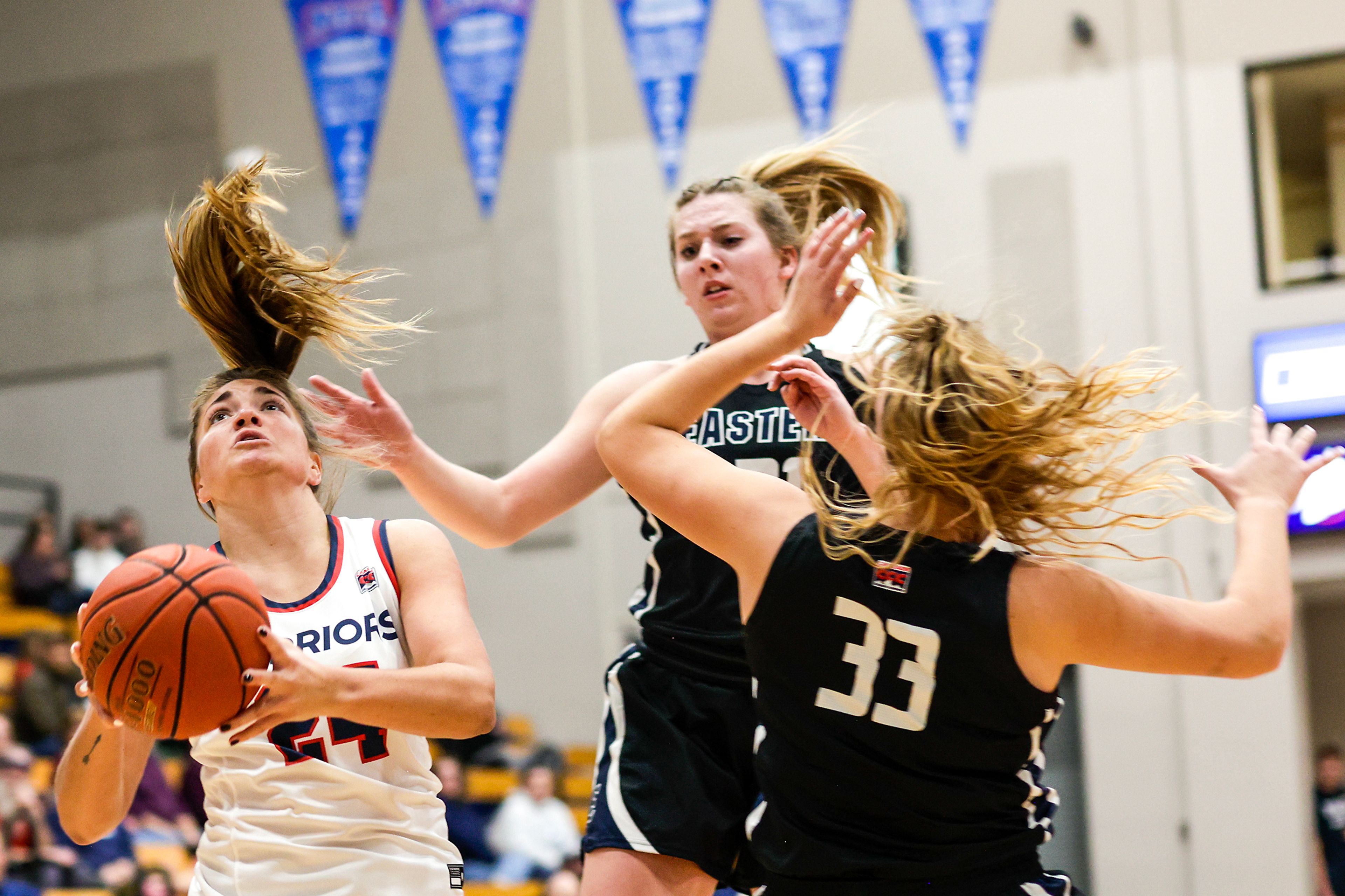 Lewis-Clark State guard Payton Hymas, left, collides with Eastern Oregon forward Haley Robinett before taking a shot during a Cascade Conference game Friday at Lewis-Clark State College.