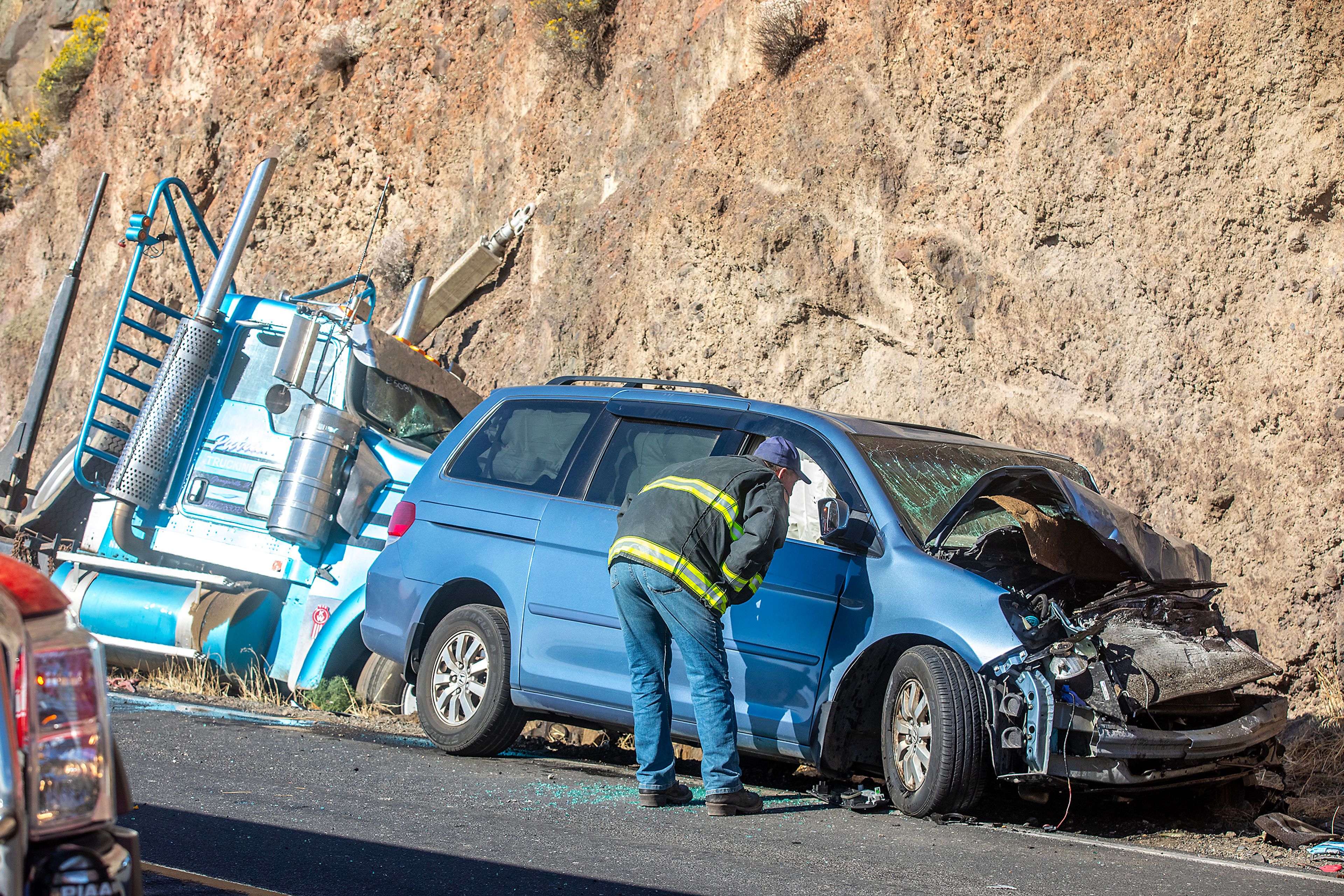 A firefighter looks into the window of a van involved in a wreck with a logging truck, left, along Washington State Route 128, near its intersection with Red Wolf Crossing Bridge, on Tuesday morning. The drivers of the two vehicles were taken to the hospital with non-life-threatening injuries. The driver of the van had to be extracted. First responders closed the road completely for about a half-hour, then were able to allow traffic to pass along a single lane. The wreck happened on the north side of the bridge, which is in Whitman County. Several agencies responded to the wreck, including the Asotin County Fire District, Lewiston Fire Department, Clarkston Police Department, Asotin County Sheriff's Office and Whitman County Fire District.