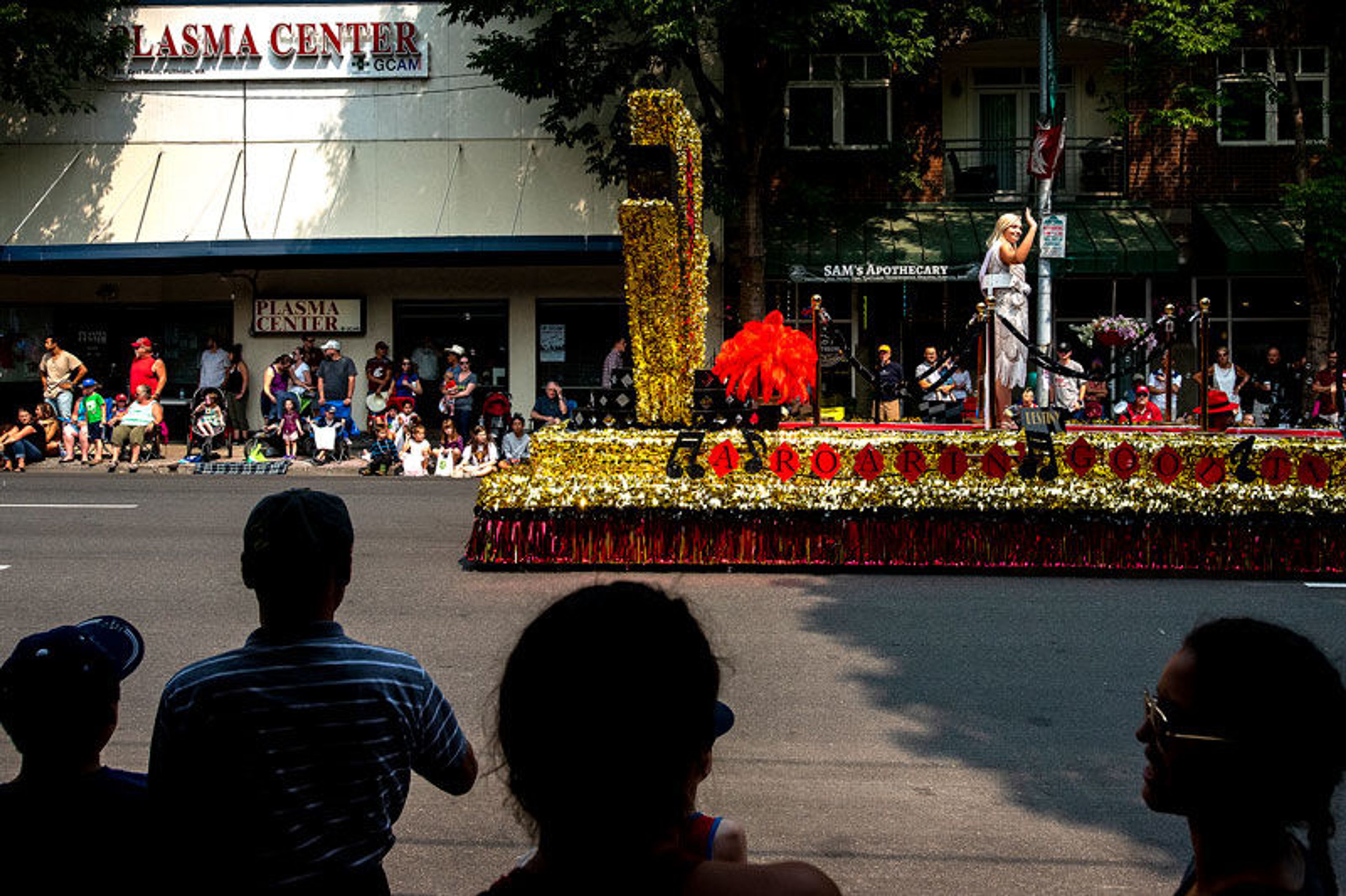 People look on from the shady sidewalks as colorful floats decorate Main Street in downtown Pullman for the National Lentil Festival parade on Saturday.