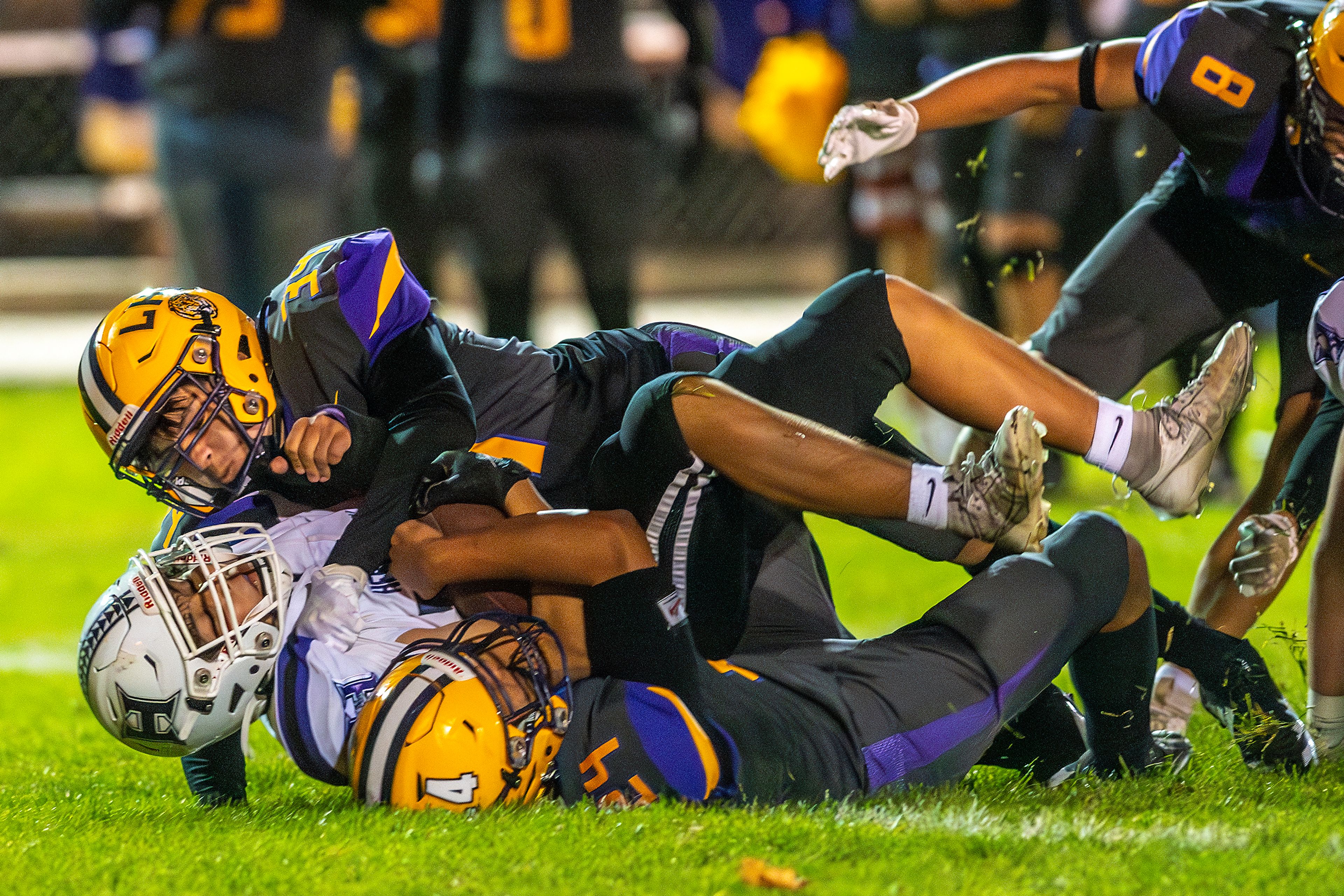 Lewiston lienbackers Isaiah Rinehart (24) and Gianni Lacuesta bring down Hermiston running back Kole Mikami during a nonconference game at Bengal Field Friday in Lewiston.,