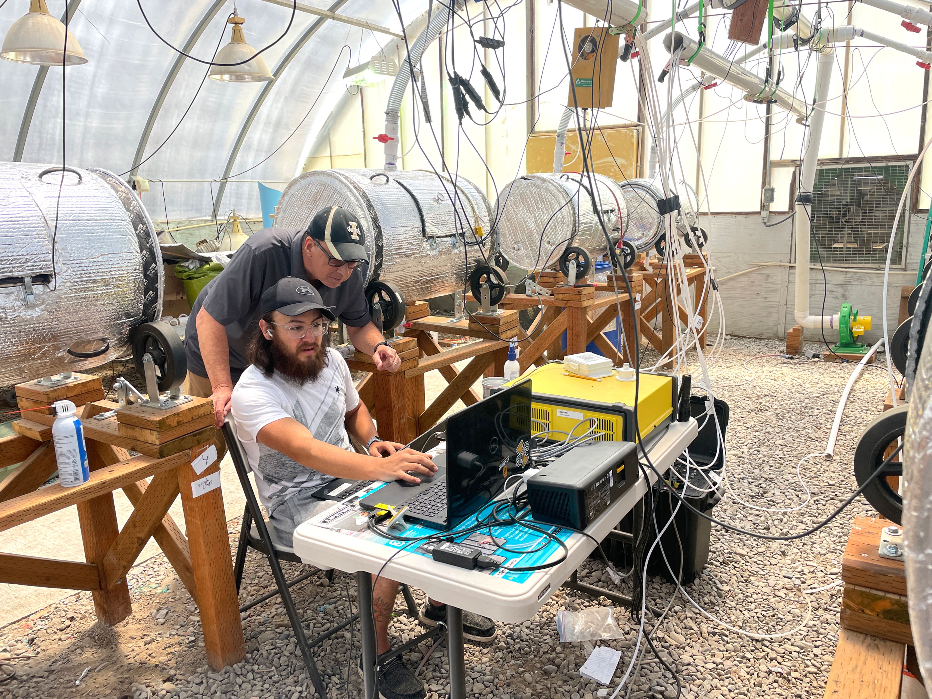 Anthony Simerlink (seated) and Mario de Haro-Marti monitor emissions as their system converts manure into compost, using amendments to improve the finished product while reducing emissions.