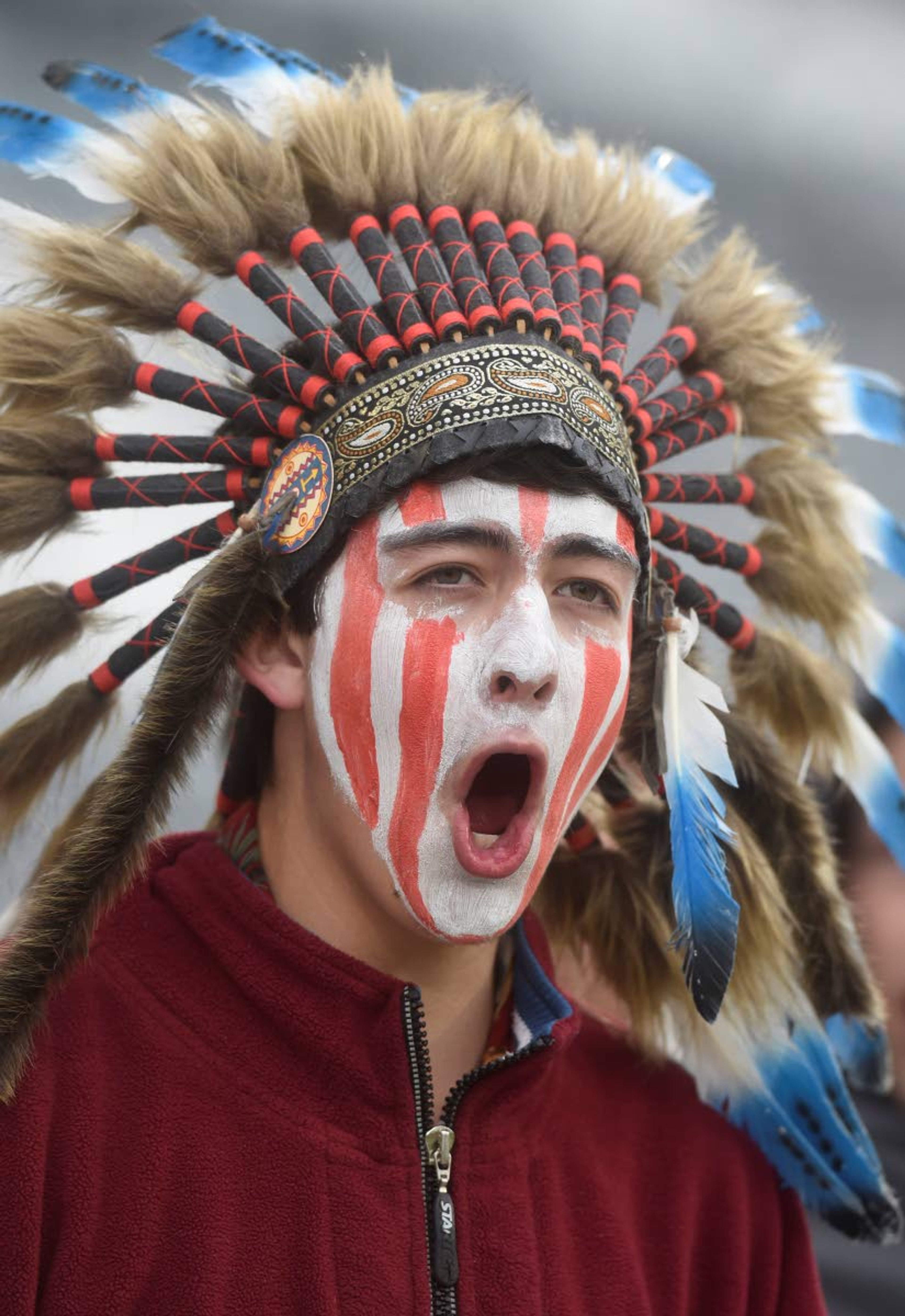 FILE - In this May 20, 2015, file photo, a Cheyenne Mountain High School student wears a headdress and face paint as he cheers for his school -- which uses "Indians" as its team mascot -- in the 4A State Soccer Championship game at Dick's Sporting Goods Park in Commerce City, Colo. The U.S. has spent most of 2019 coming to grips with blackface and racist imagery, including a racist photo on the Virginia governor’s college yearbook page. But Native Americans say they don't see significant pressure applied to those who perpetuate Native American stereotypes. (Mark Reis/The Gazette via AP, File)