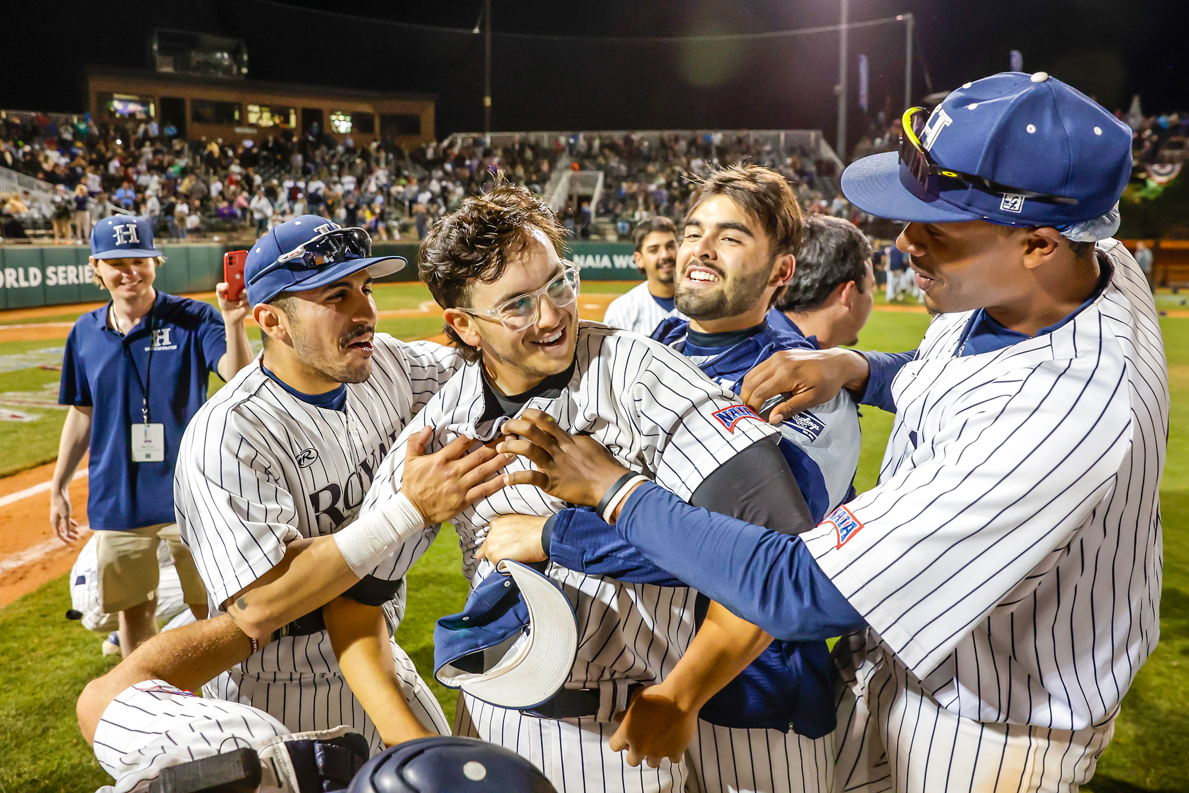 Hope International’s Trey Seeley is embraced after they defeated Tennessee Wesleyan 13-6 in Game 19 of the NAIA World Series at Harris Field Friday in Lewiston.