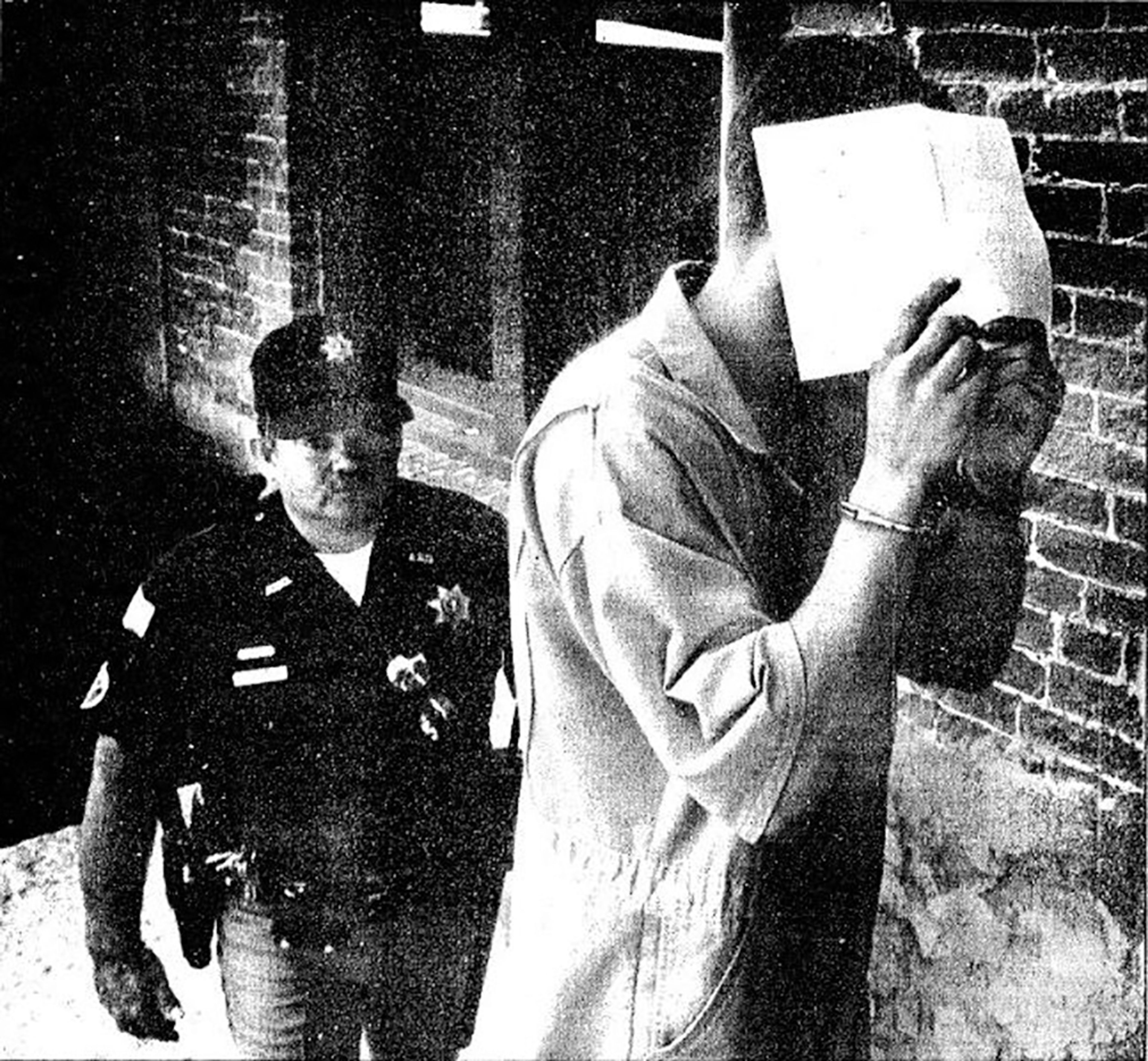 Asotin County Sheriff's Deputy Eric Springston escorts Kyle F. Johnson into the Asotin County Courthouse prior to Johnson's arraignment June 6, 1989.