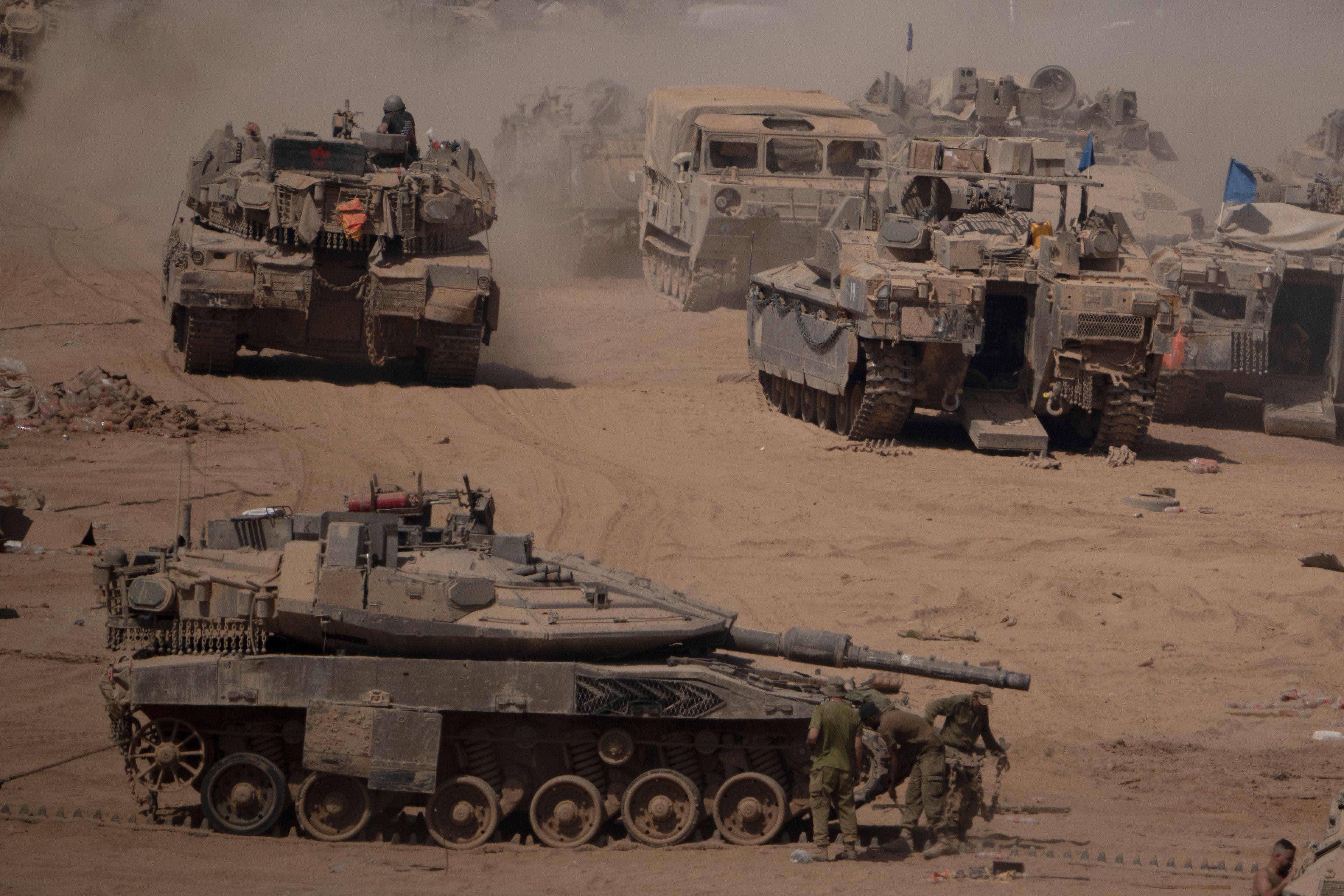 Israeli soldiers work on a tank in a staging area near the Israeli-Gaza border in southern Israel, Monday, June 3, 2024.