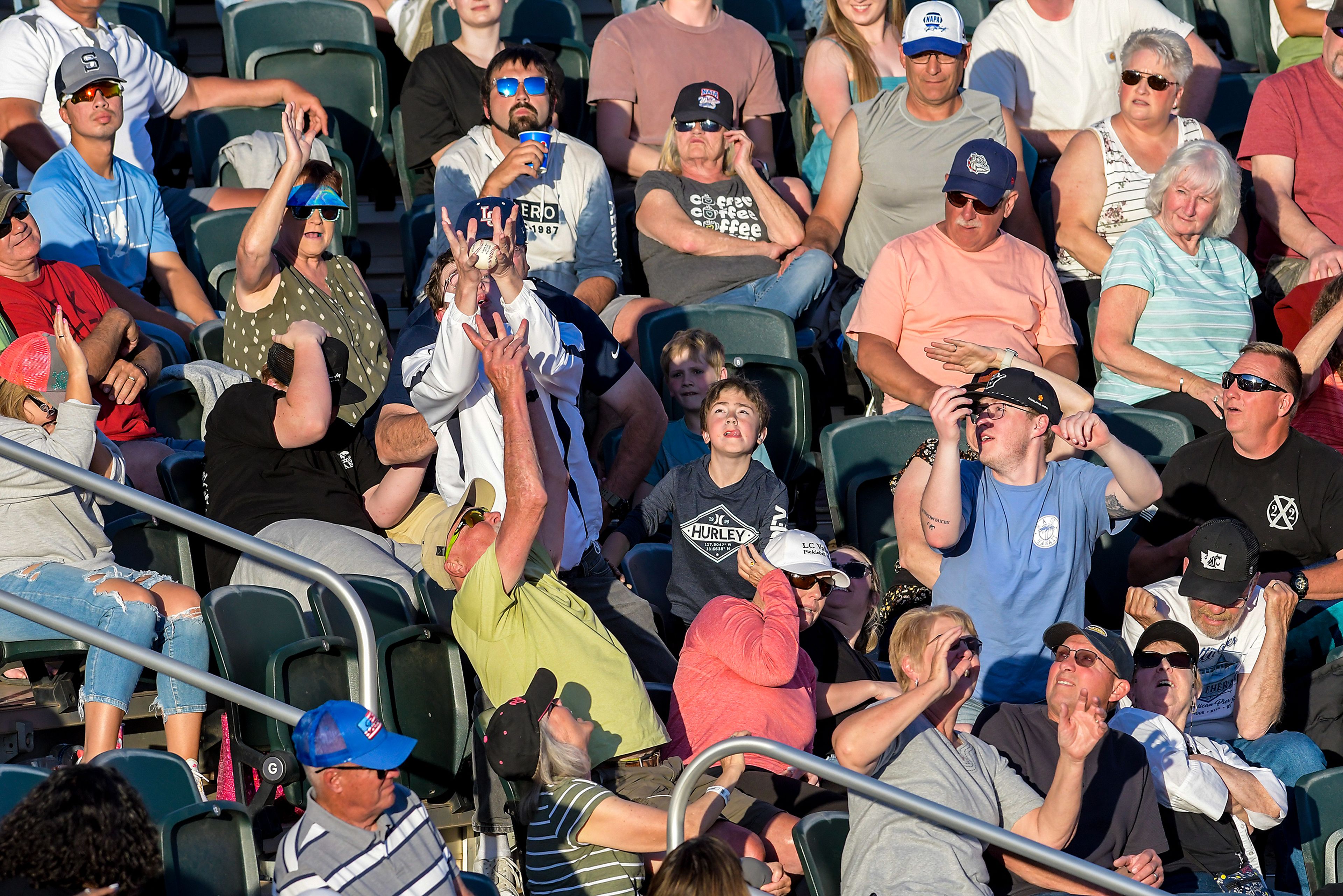 A fan catches a foul ball in Hope International versus Tennessee Wesleyan in Game 19 of the NAIA World Series at Harris Field Friday in Lewiston.