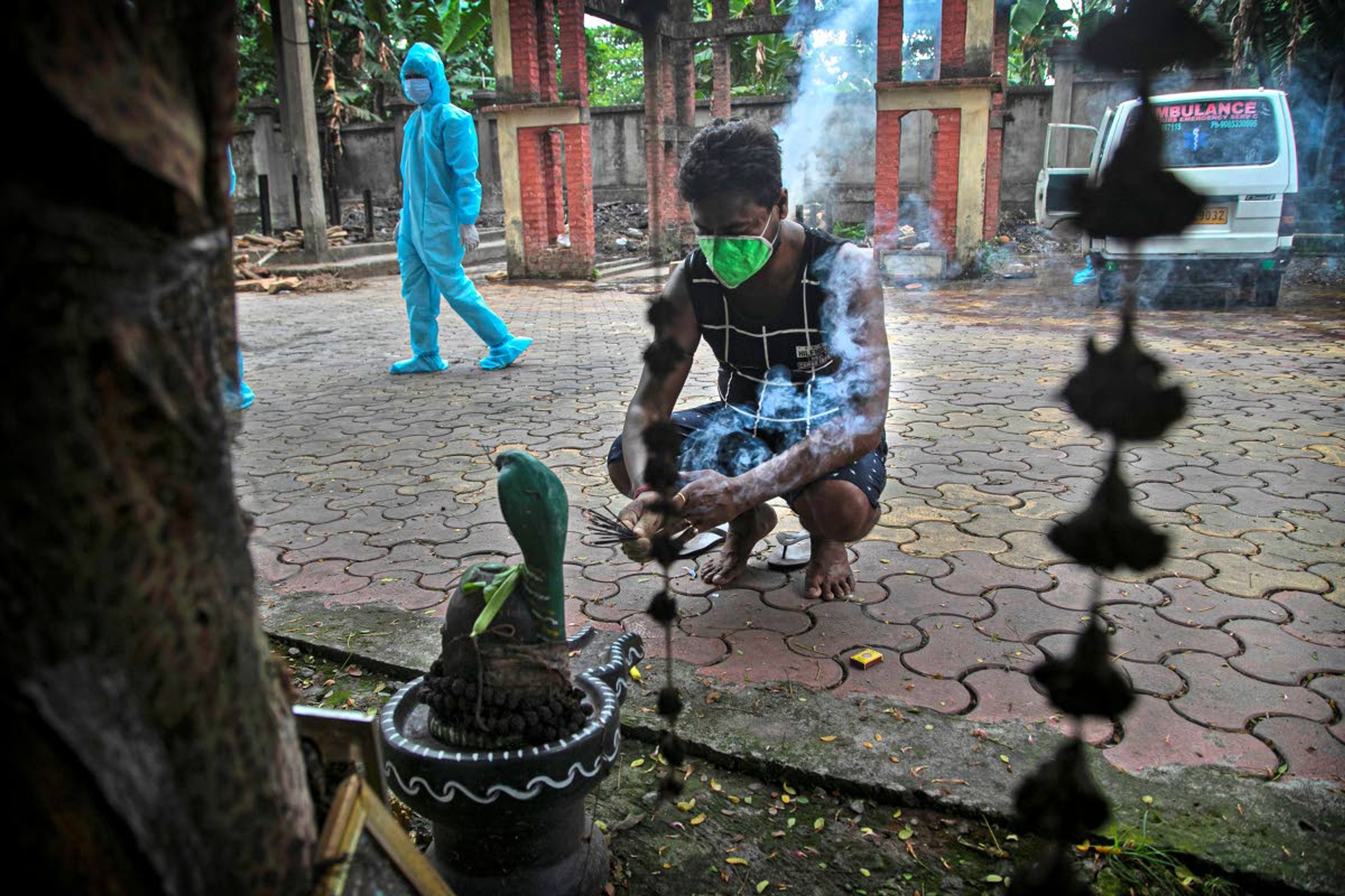 Ramananda Sarkar, 43, offers prayers to Hindu god Shiva before cremating the body of a COVID-19 victim in Gauhati, India, Tuesday, Sept. 15, 2020. While Hindu's believe cremation rights are sacred and release the dead person's soul from the cycle of rebirth, those who actually deal with corpses are looked down upon. It's a stigma that's only been made worse by the coronavirus, which has killed more than 100,000 people in India out of 6.4 million reported infections. (AP Photo/Anupam Nath)