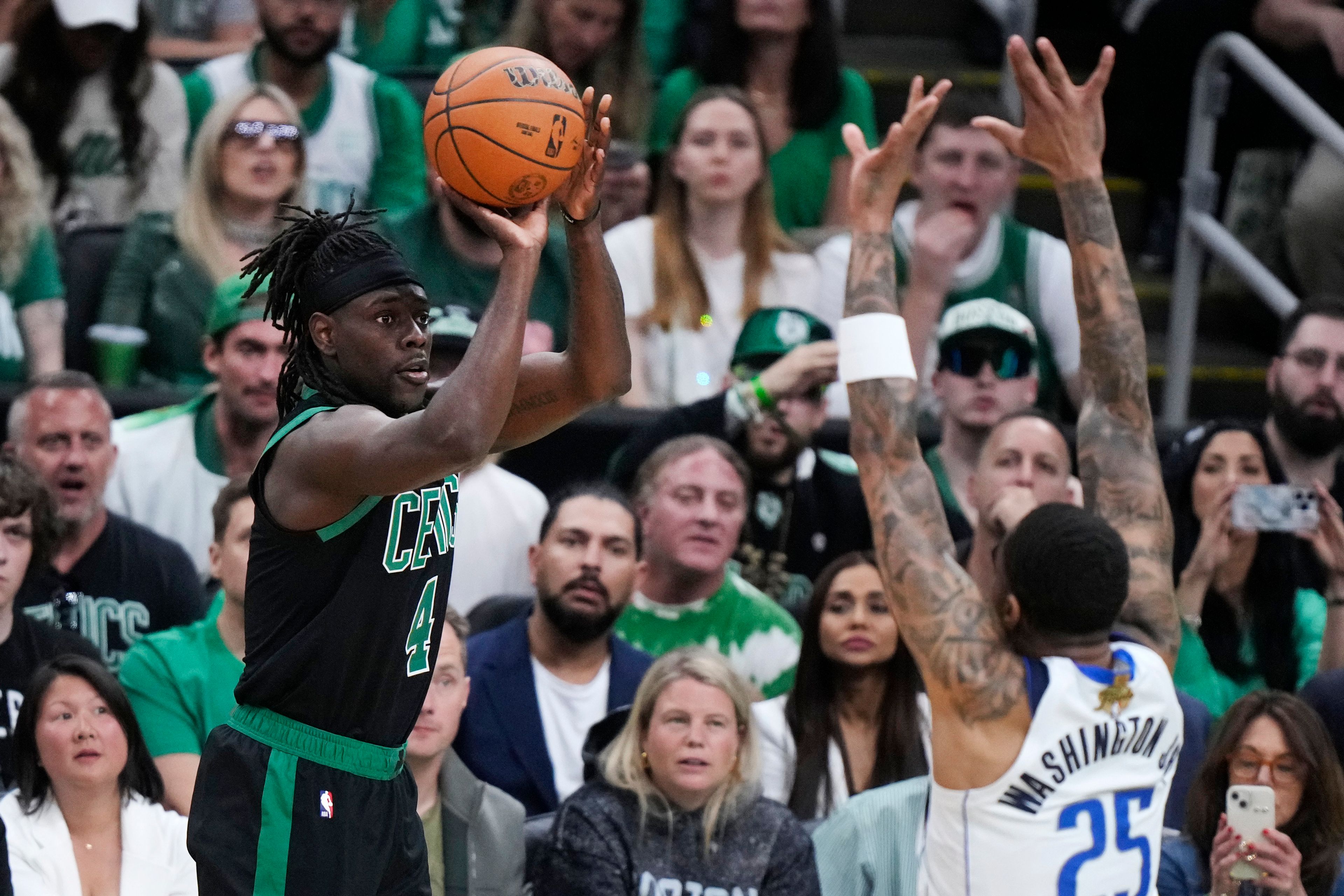 Boston Celtics guard Jrue Holiday takes a shot over Dallas Mavericks forward P.J. Washington (25) during the first half of Game 2 of the NBA Finals basketball series, Sunday, June 9, 2024, in Boston.