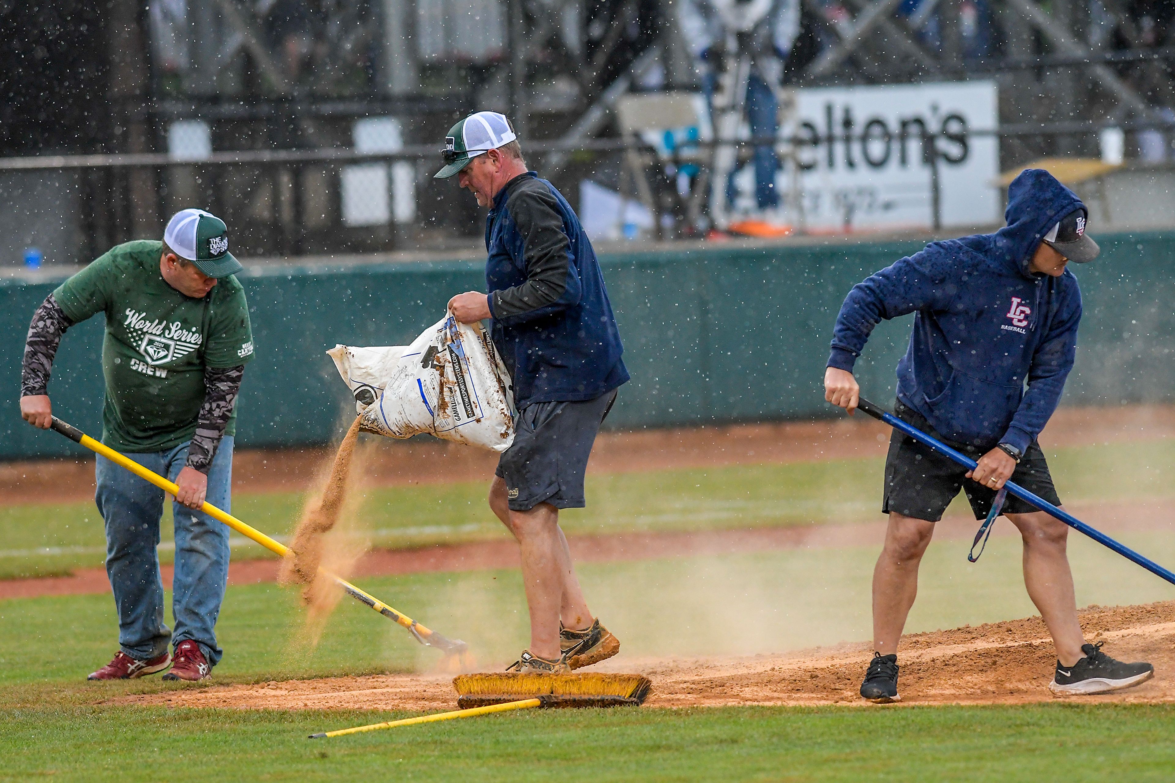 Members of the Diamond Crew work on the pitchers mound as rain comes down during a contest between Tennessee Wesleyan and Cumberlands in game 3 of the NAIA World Series at Harris Field Friday in Lewiston.