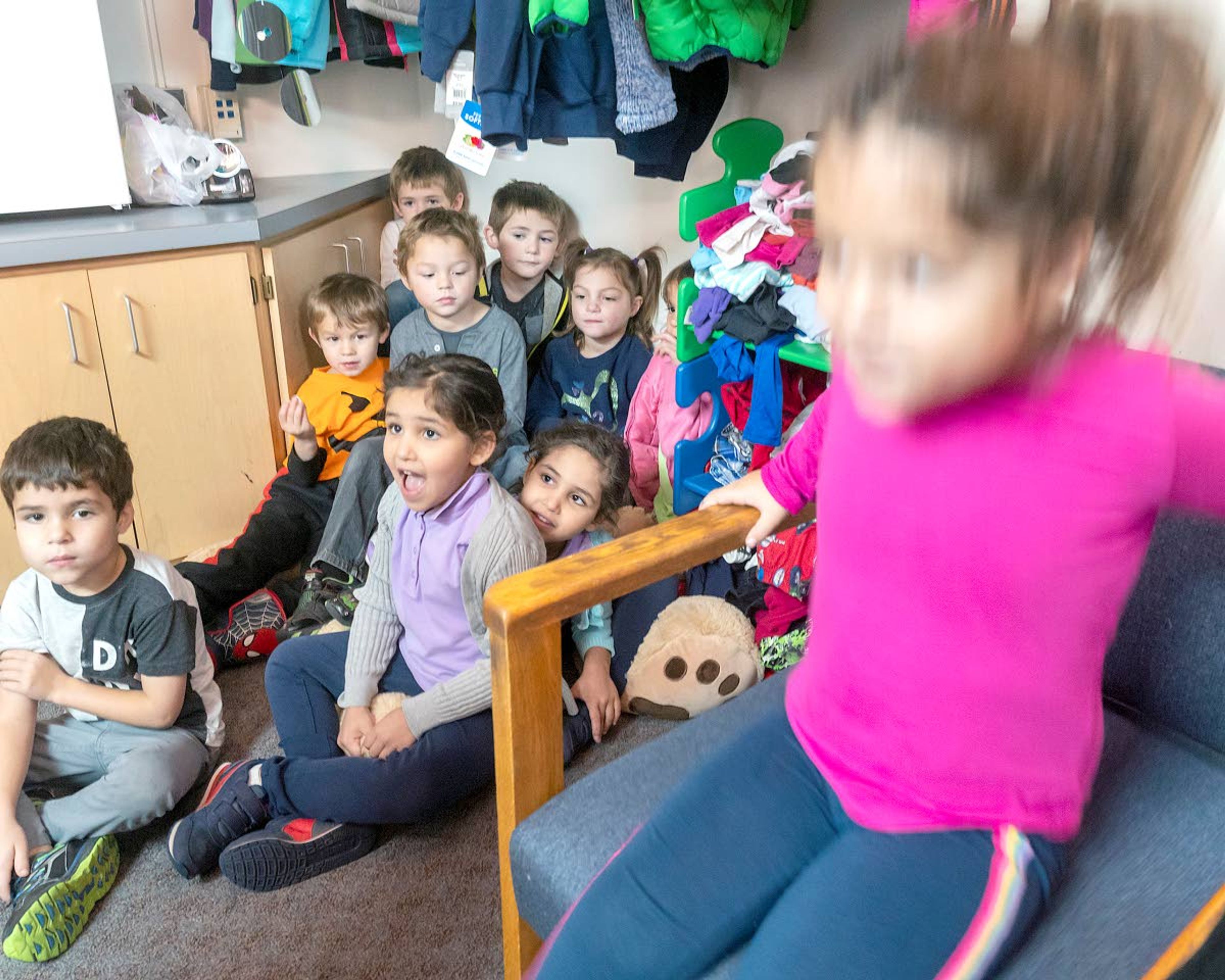 Nine of the 10 twins were relatively still for a moment to answer a couple of questions, while Naomi Shawer, 5 (right) bounces in a chair at Grantham Elementary in Clarkston.