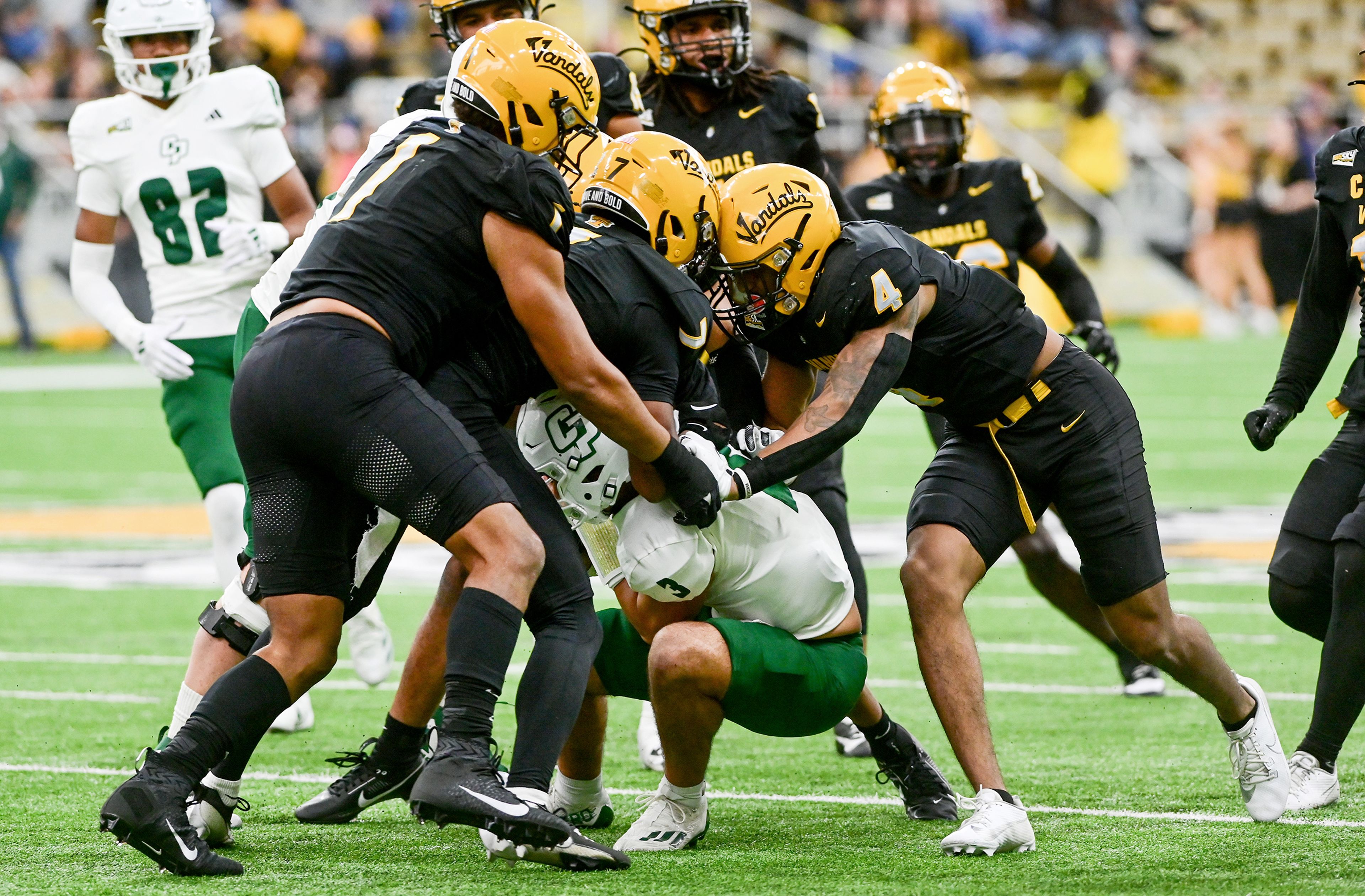 Idaho defensive lineman Keyshawn James-Newby, defensive back Andrew Marshall and Idaho linebacker Isiah King tackle Cal Poly quarterback Bo Kelly on Saturday at the P1FCU Kibbie Dome in Moscow.,