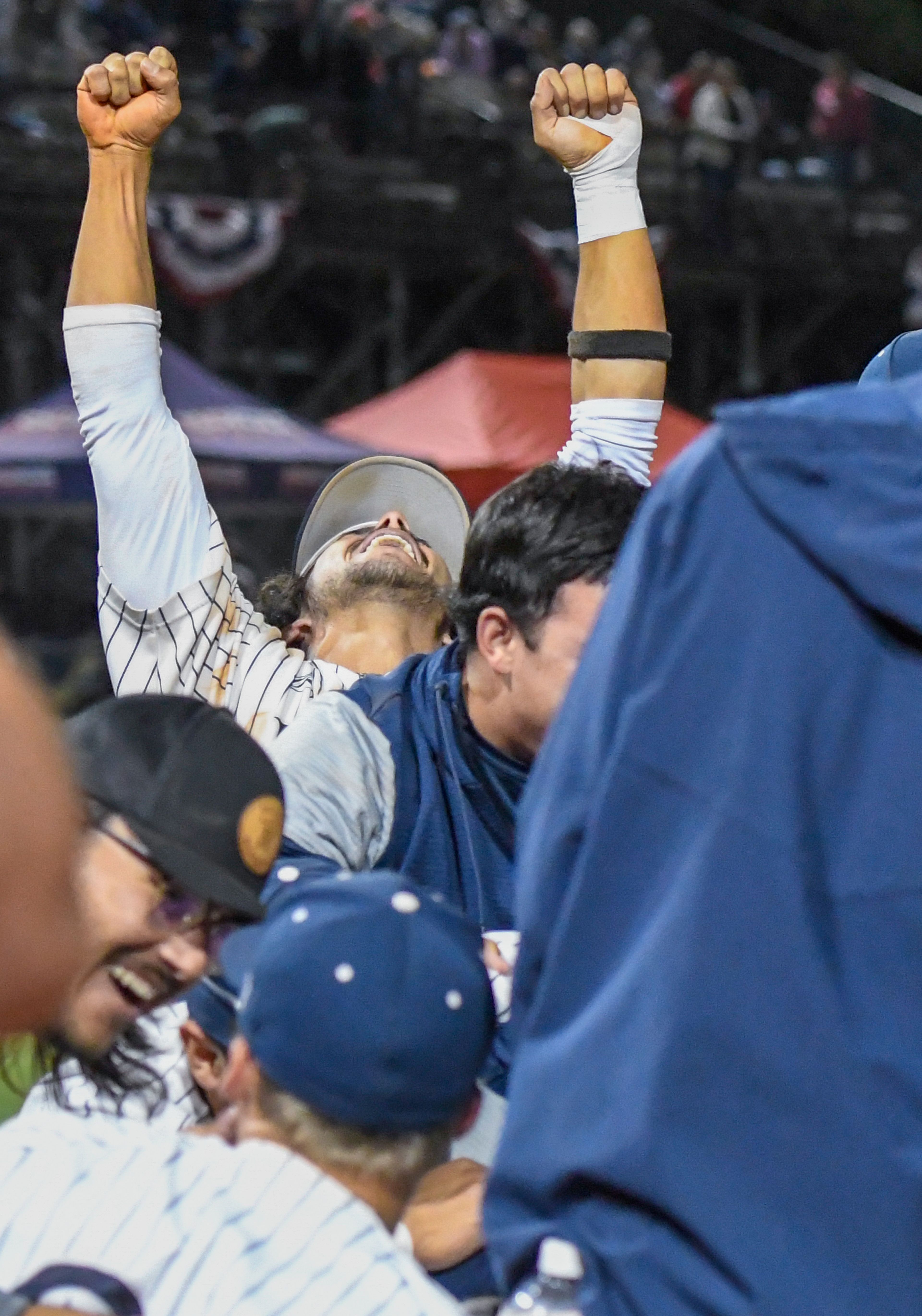 A Hope International player pulls away from the dogpile to raise his arms in celebration of the team’s championship win in the NAIA World Series at Harris Field in Lewiston on Friday.