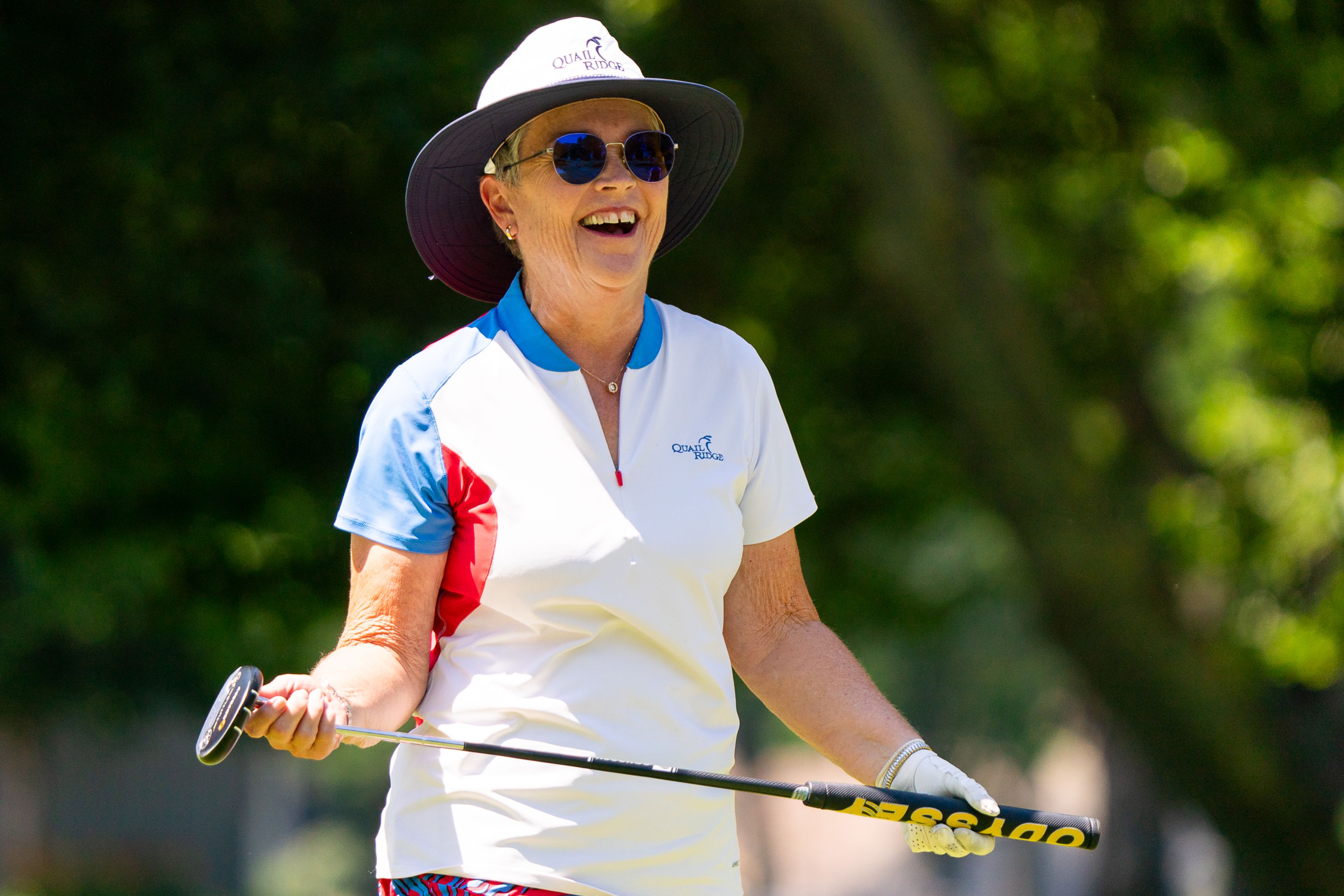 Holly Munn smiles after putting a ball into the hole during the Tribune Cup women’s golf tournament on Tuesday at Red Wolf Golf Club in Clarkston. Munn represented Quail Ridge Golf Course during the tournament.