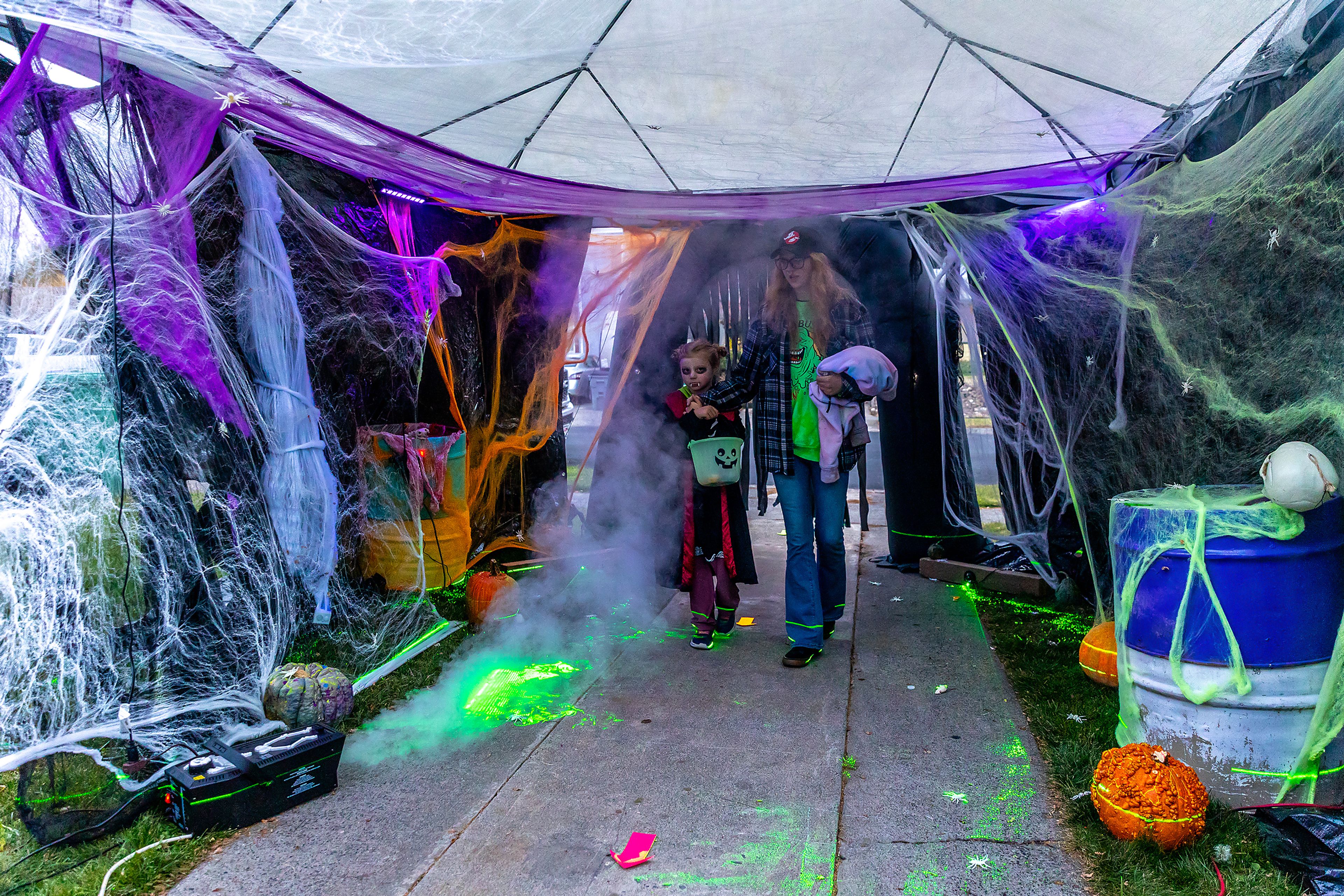 Haley Semmes and Thea Semmes, 5, dressed as a vampire, move through a tunnel Thursday in the Sunset Drive neighborhood in Lewiston.