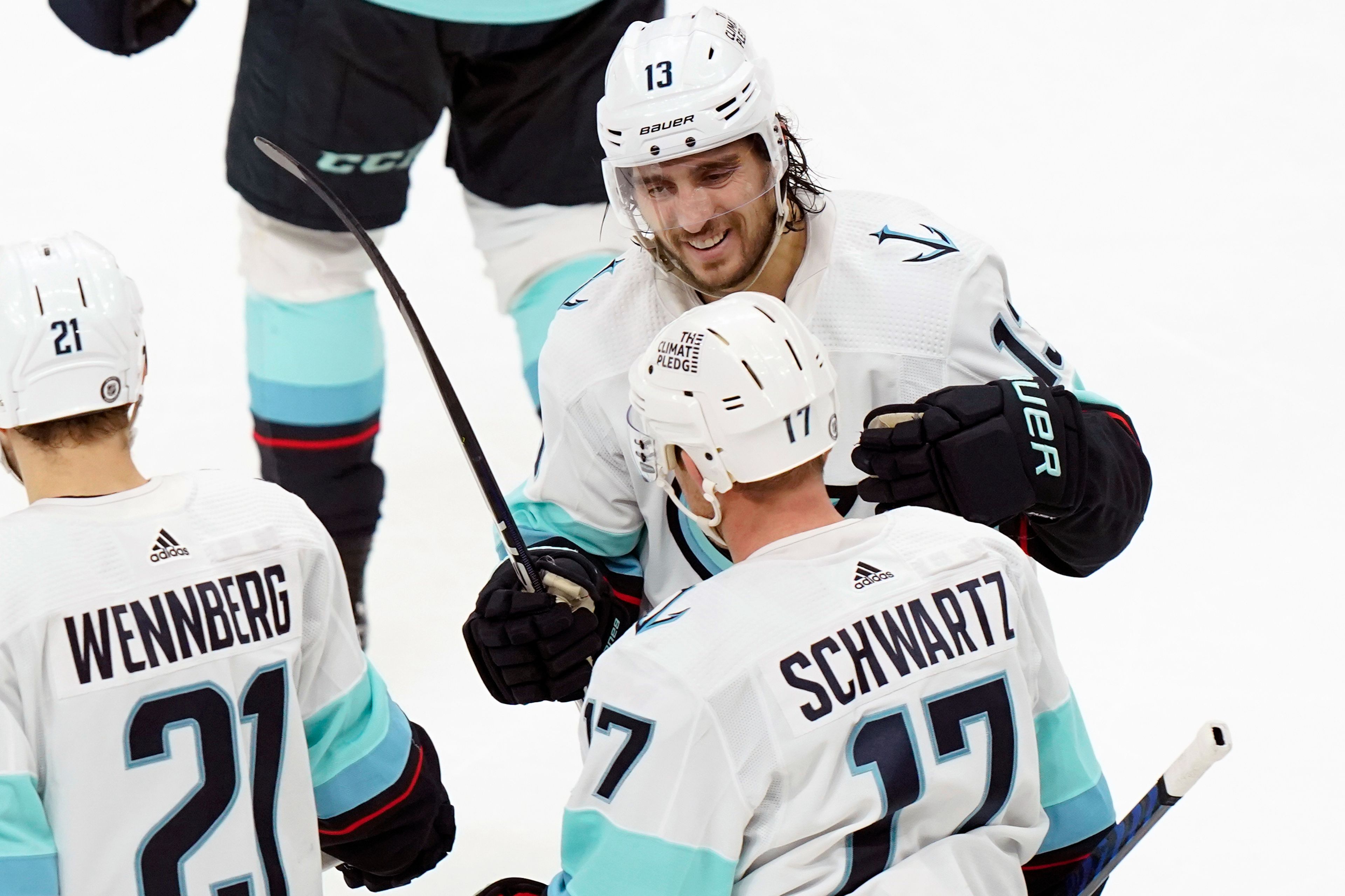 Seattle Kraken left wing Brandon Tanev (13) celebrates with center Jaden Schwartz (17) after Schwartz scored in the third period of an NHL hockey game against the Boston Bruins, Thursday, Jan. 12, 2023, in Boston. (AP Photo/Steven Senne)