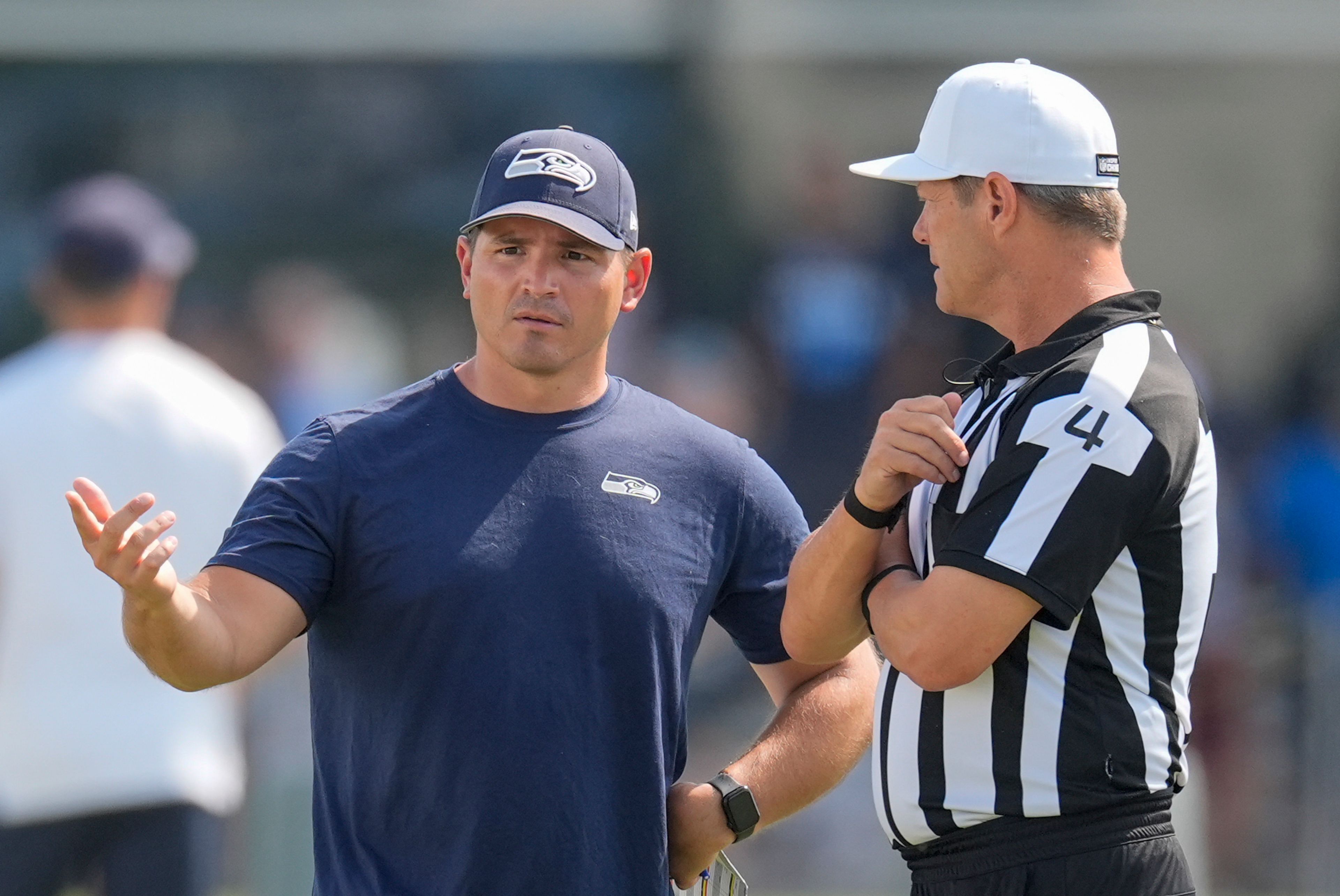 Seattle Seahawks head coach Mike Macdonald, left, speaks with an official during an NFL joint football training camp practice with the Tennessee Titans, Thursday, Aug. 15, 2024, in Nashville, Tenn. (AP Photo/George Walker IV)