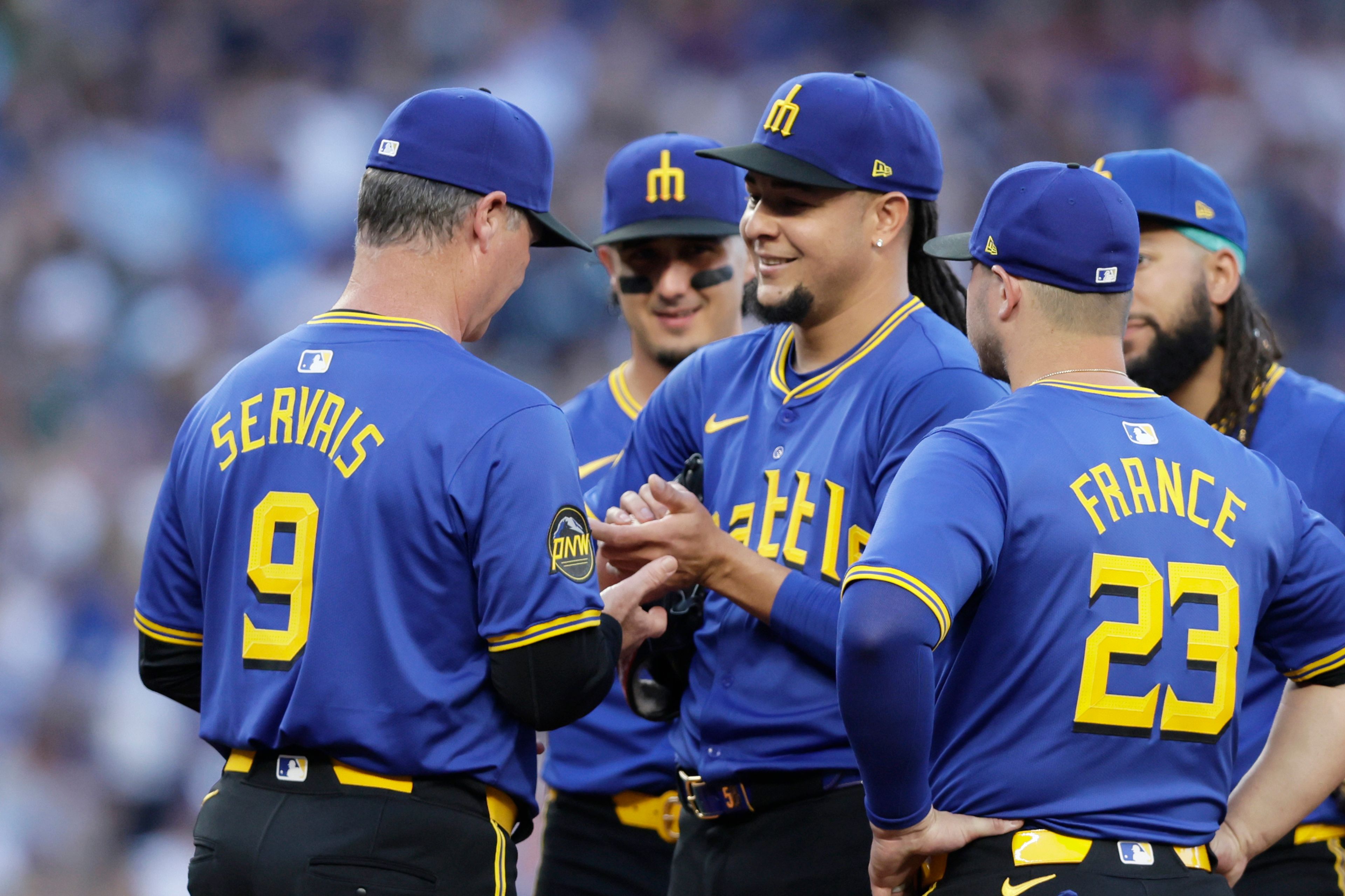 Seattle Mariners starting pitcher Luis Castillo, denter, smiles at manager Scott Servais (9) who asks for the ball to replace him during the seventh inning against the Toronto Blue Jays in a baseball game, Friday, July 5, 2024, in Seattle. (AP Photo/John Froschauer)