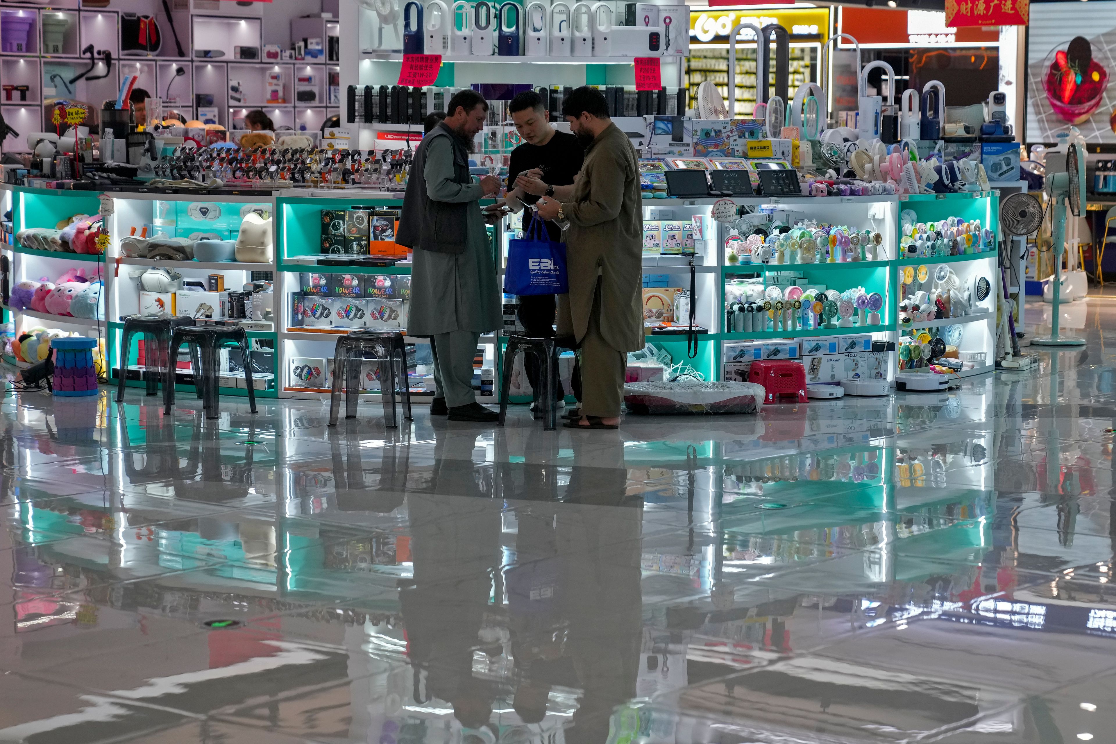 Foreign buyers check prices with a vendor at a store selling electronic products at the Yiwu wholesale market in Yiwu, east China's Zhejiang province on Nov. 8, 2024. (AP Photo/Andy Wong)