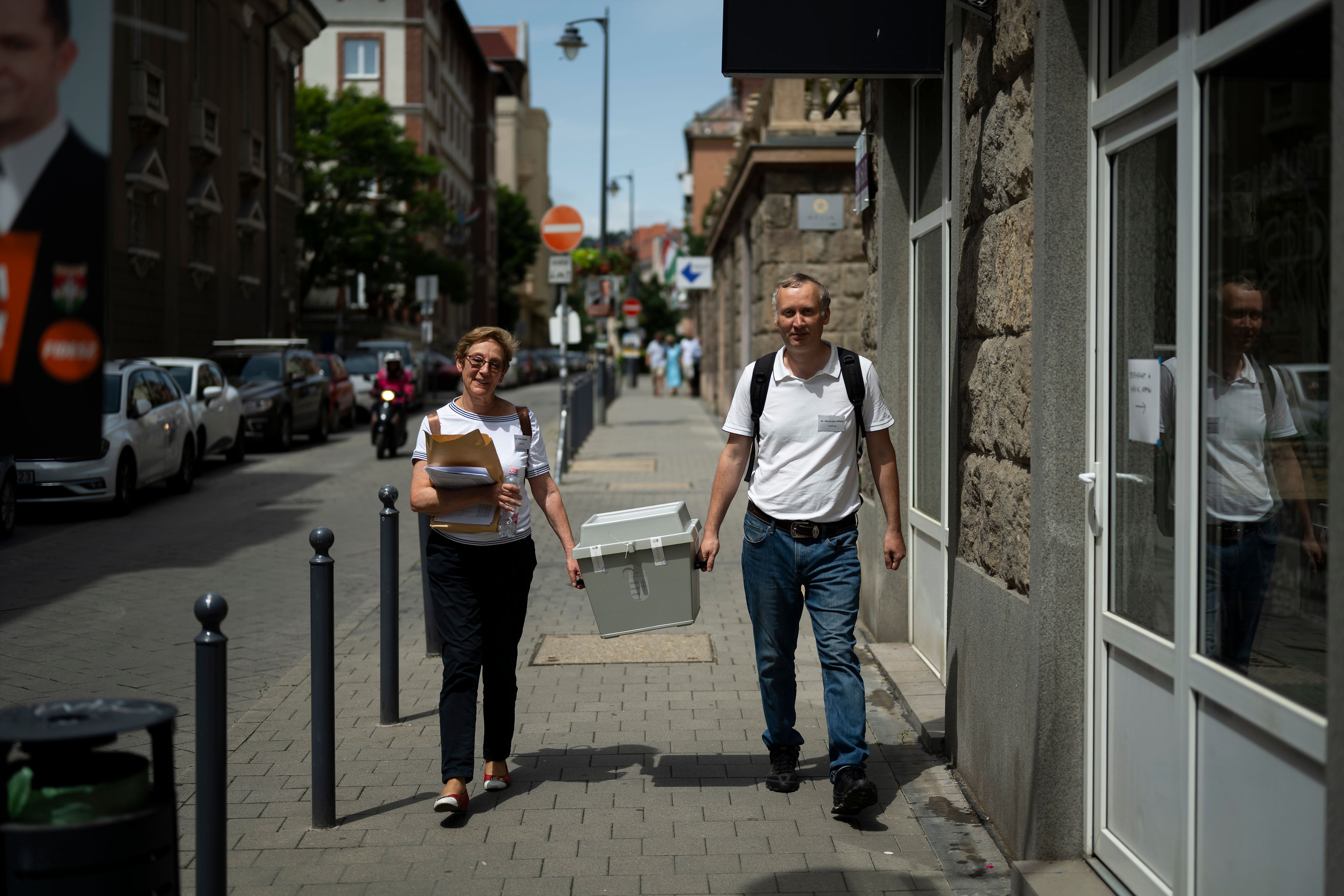 Ballot counters walk with a mobile ballot box during the European Parliamentary elections in Budapest, Hungary, Sunday, June 9, 2024.