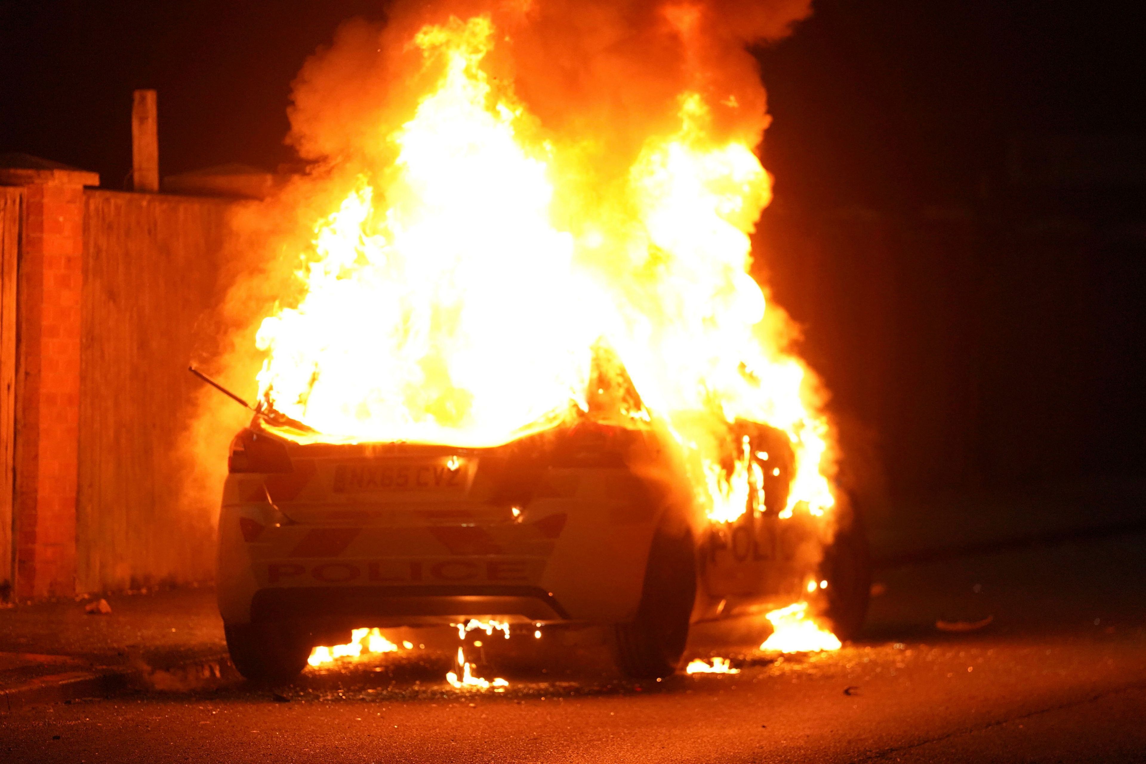 A police car burns as police officers are deployed on the streets of Hartlepool, England, following a violent protest in the wake of the killing of three girls who were fatally stabbed in northwest England, Wednesday, July 31, 2024. Far-right groups seek to stir anger over an attack they have sought to link — without evidence — to immigrants. (Owen Humphreys/PA via AP)