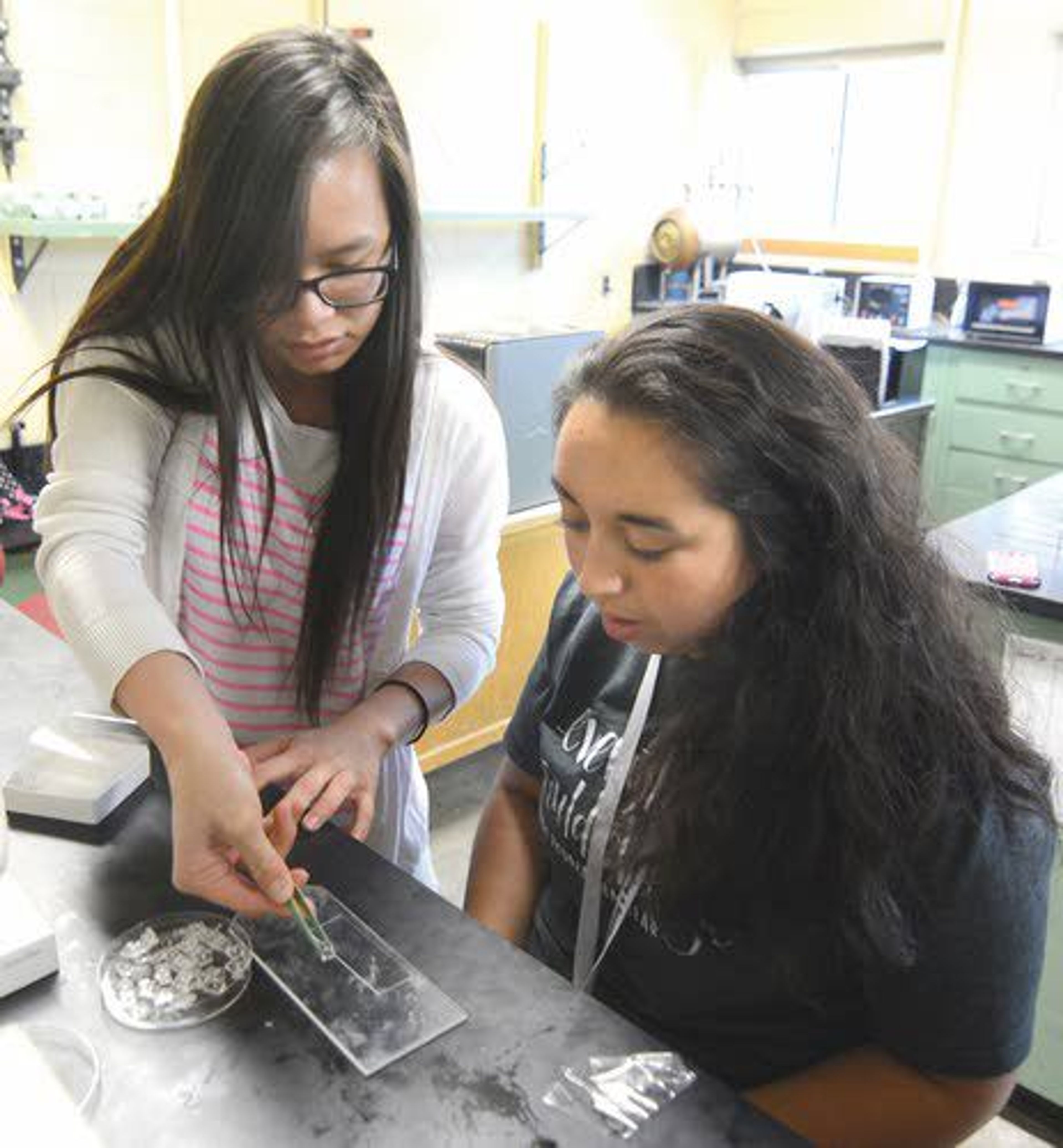 University of Idaho undergraduate student Amanda Vu works with summer camper Kiara Garcia on creating a way to identify infected cells.