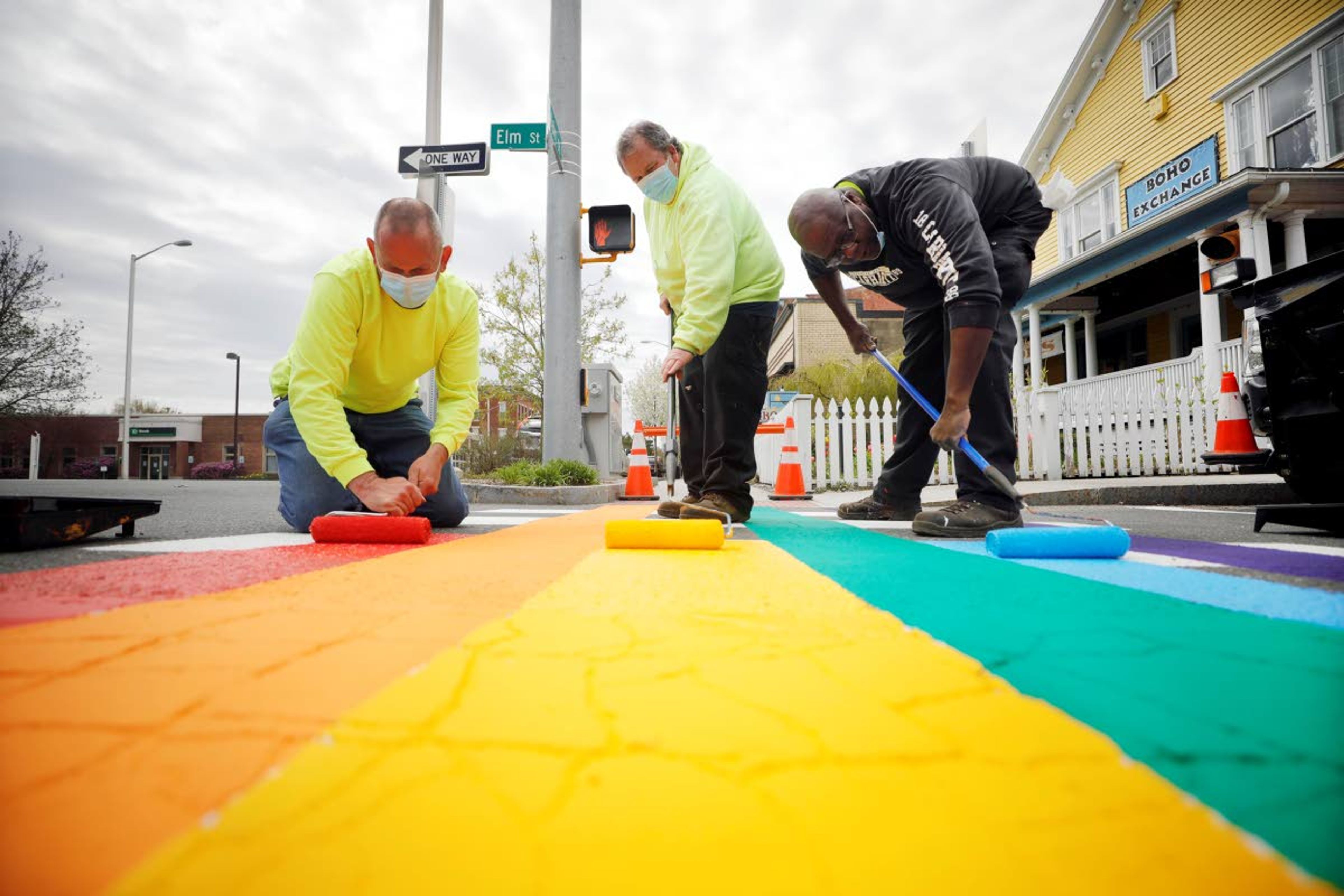 Matt Pevzner, left, Tim Hosier, center, and Darryl Austin of the Great Barrington Highway Department paint over the crosswalk on Elm Street with brightly colored rainbow stripes, Wednesday, May 6, 2020 in Great Barrington, Mass. In solidarity with the worldwide movement of displaying rainbow colors as a sign of hope amid the COVID-19 crisis, the crew planned to paint five crosswalks in downtown Great Barrington and one in Housatonic. (Stephanie Zollshan/The Berkshire Eagle via AP)