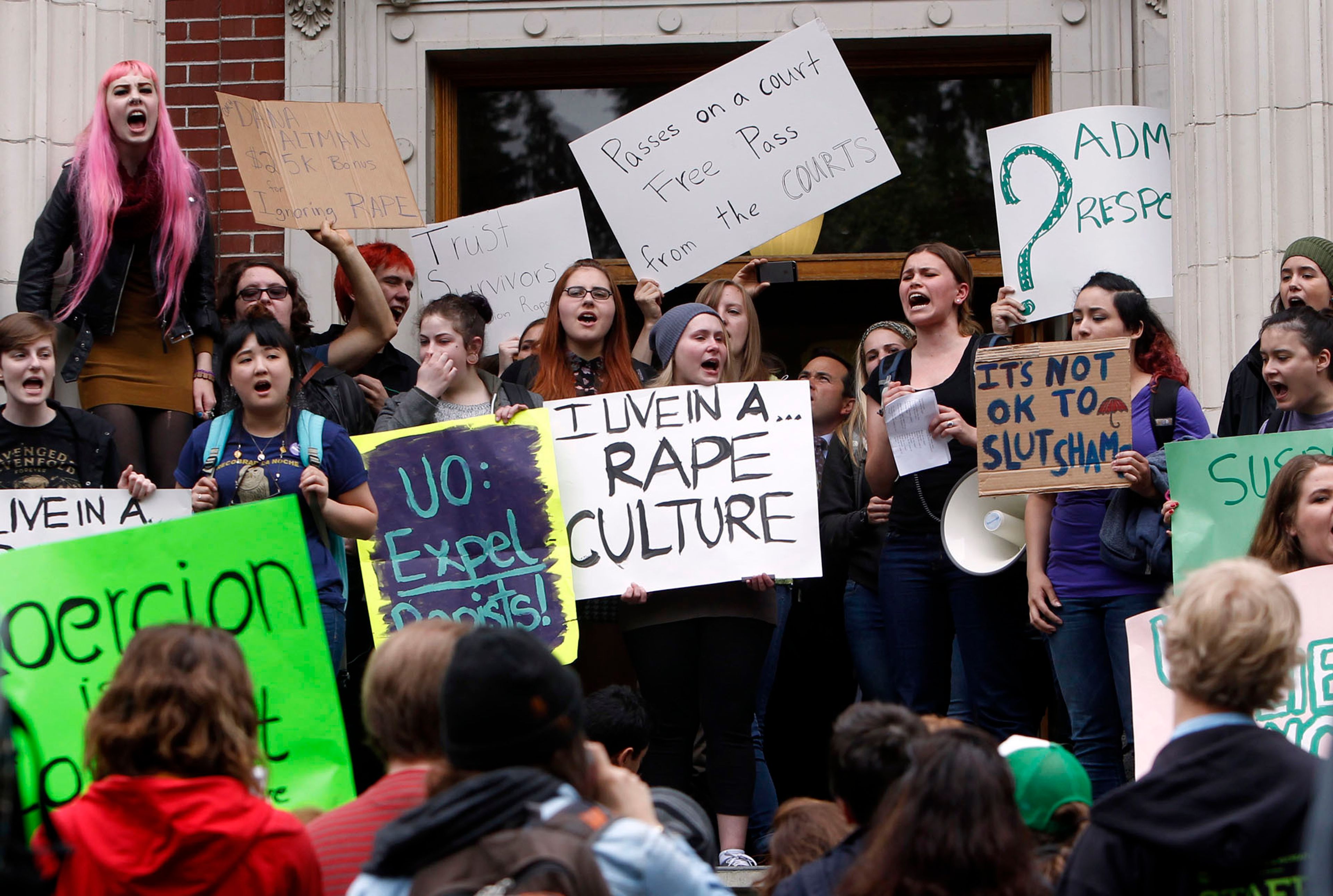 FILE - University of Oregon students and staff protest on the steps of Johnson Hall on the UO campus in Eugene, Ore. Thursday May 8, 2014, against sexual violence in the wake of allegations of rape brought against three UO basketball players by a fellow student. (AP Photo/The Register-Guard, Chris Pietsch, File)